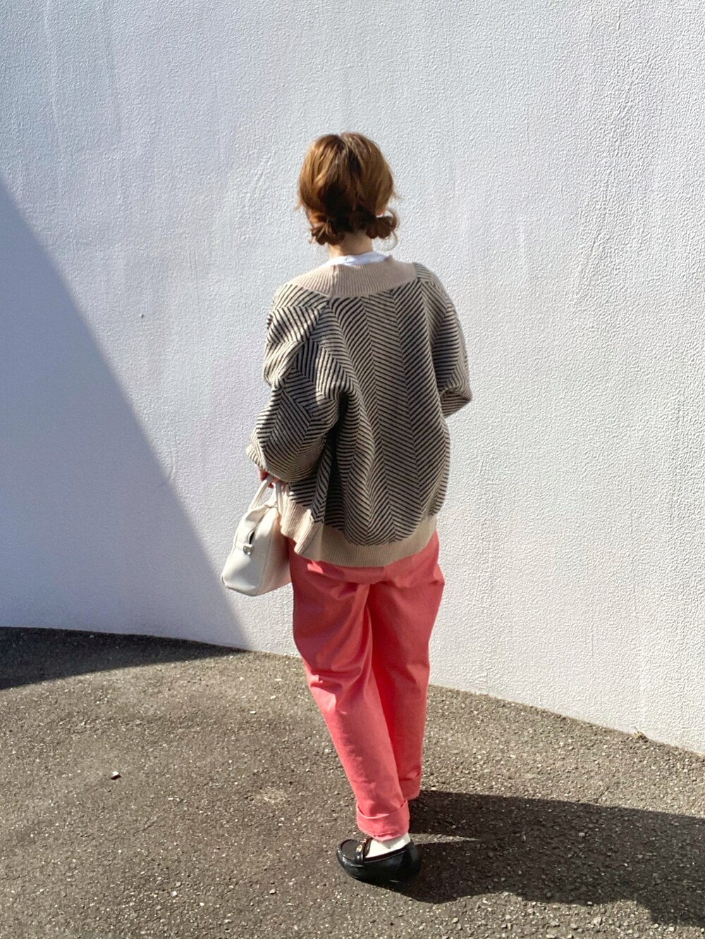 ホワイト系のTシャツ/カットソー、ブラック系のカーディガン/ボレロ、ピンク系のチノパンツを着用したレディースの春コーディネートの2枚目の写真