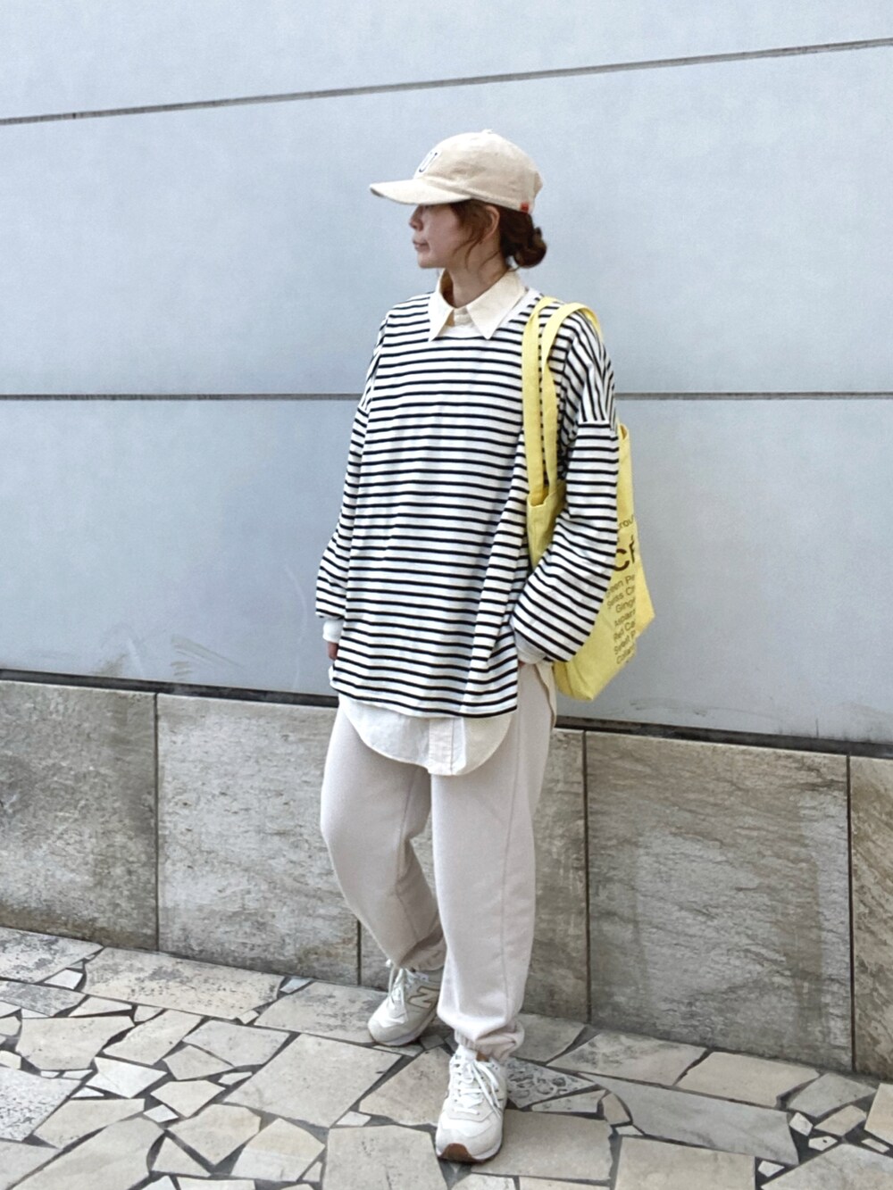 ブラック系のTシャツ/カットソー、イエロー系のトートバッグ、ホワイト系のスニーカーを着用したレディースの冬コーディネートの3枚目の写真