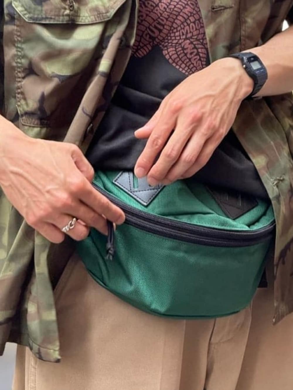 グリーン系のその他パンツ、グレー系のTシャツ/カットソー、グリーン系のボディバッグ/ウエストポーチを着用したメンズの夏コーディネートの3枚目の写真