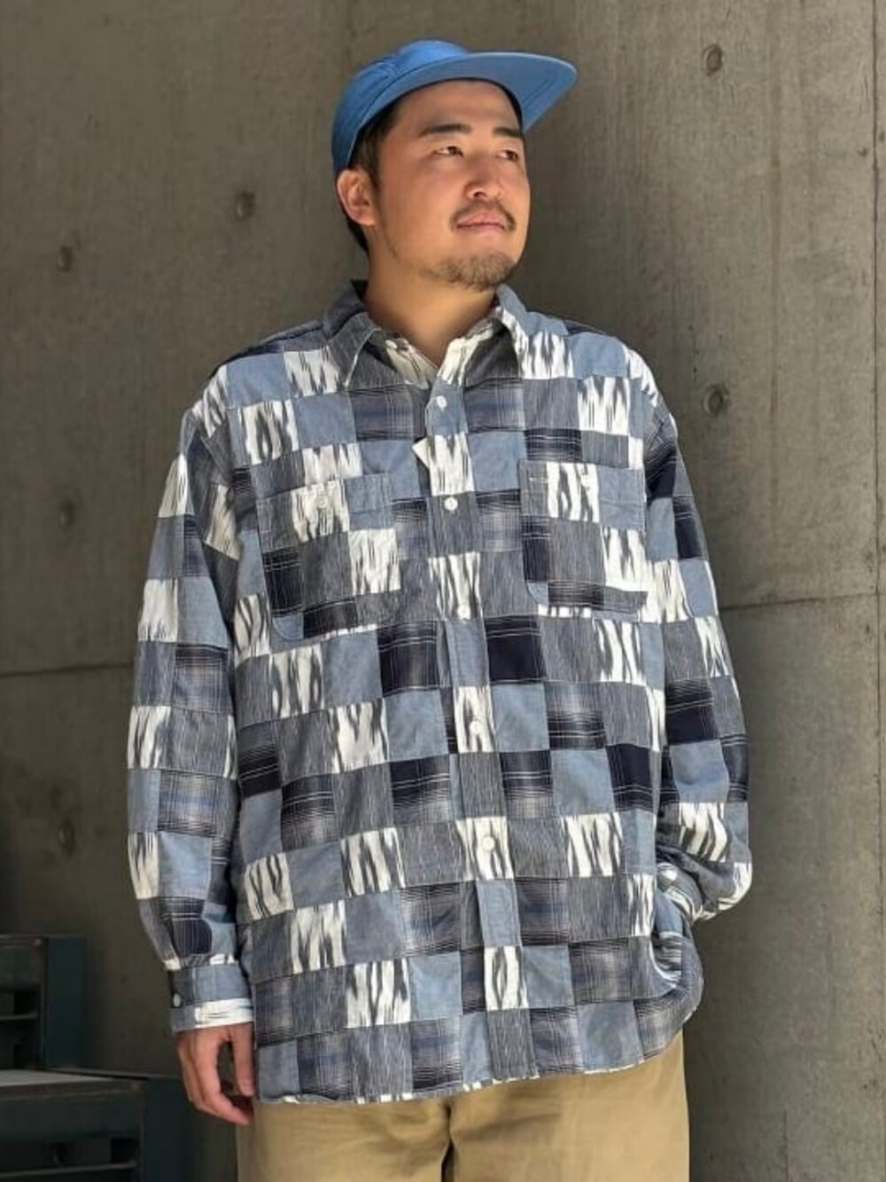 ブルー系のシャツ/ブラウス、レッド系のスニーカー、ブルー系のキャップを着用したメンズの春コーディネートの2枚目の写真