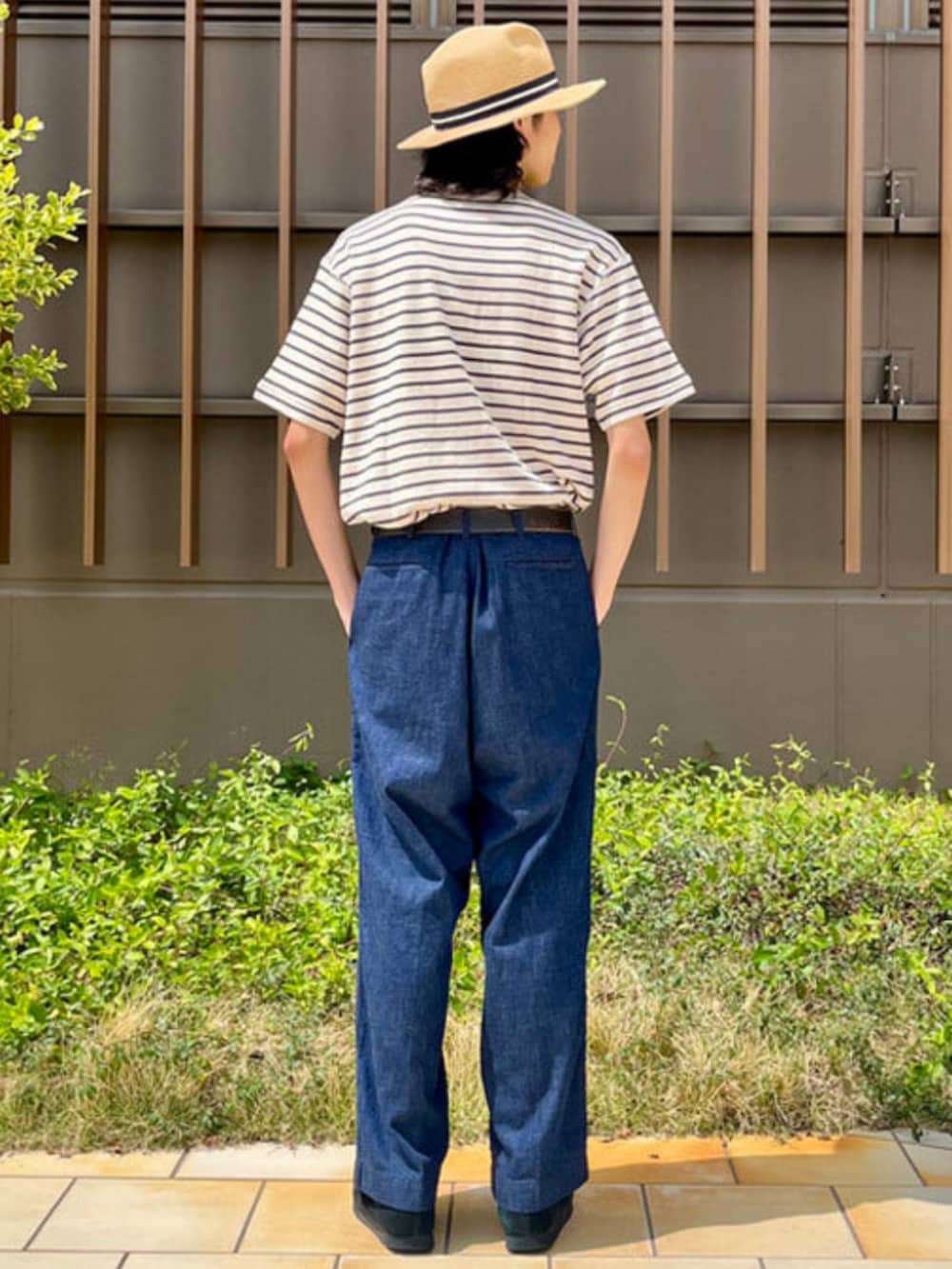 ブルー系のデニムパンツ、ホワイト系のTシャツ/カットソー、ベージュ系のハットを着用したメンズの春コーディネートの3枚目の写真