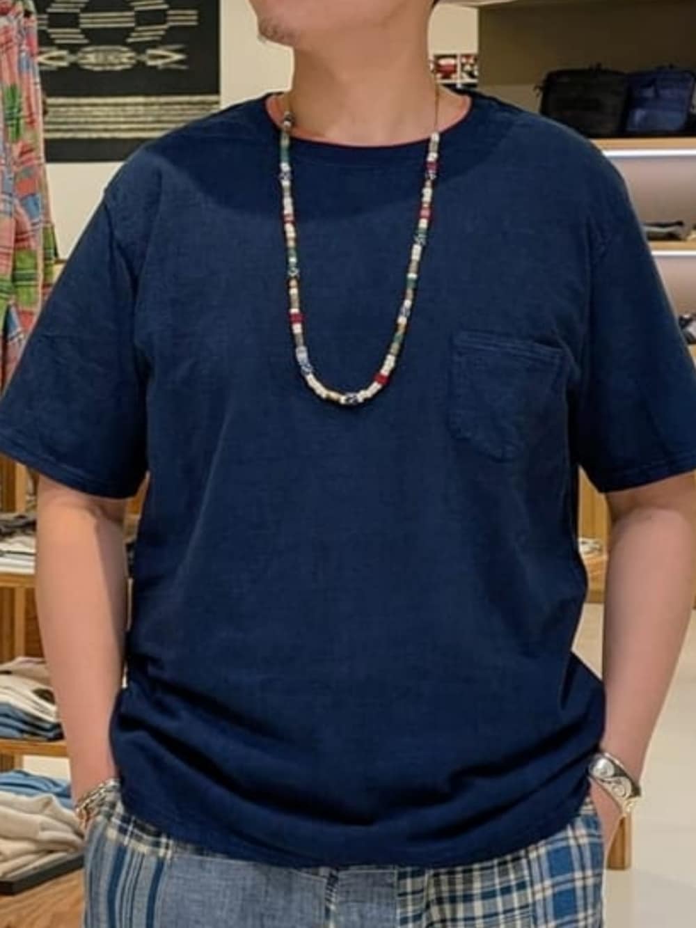 ホワイト系のスニーカー、ブルー系のTシャツ/カットソー、ベージュ系のハットを着用したメンズの夏コーディネートの2枚目の写真