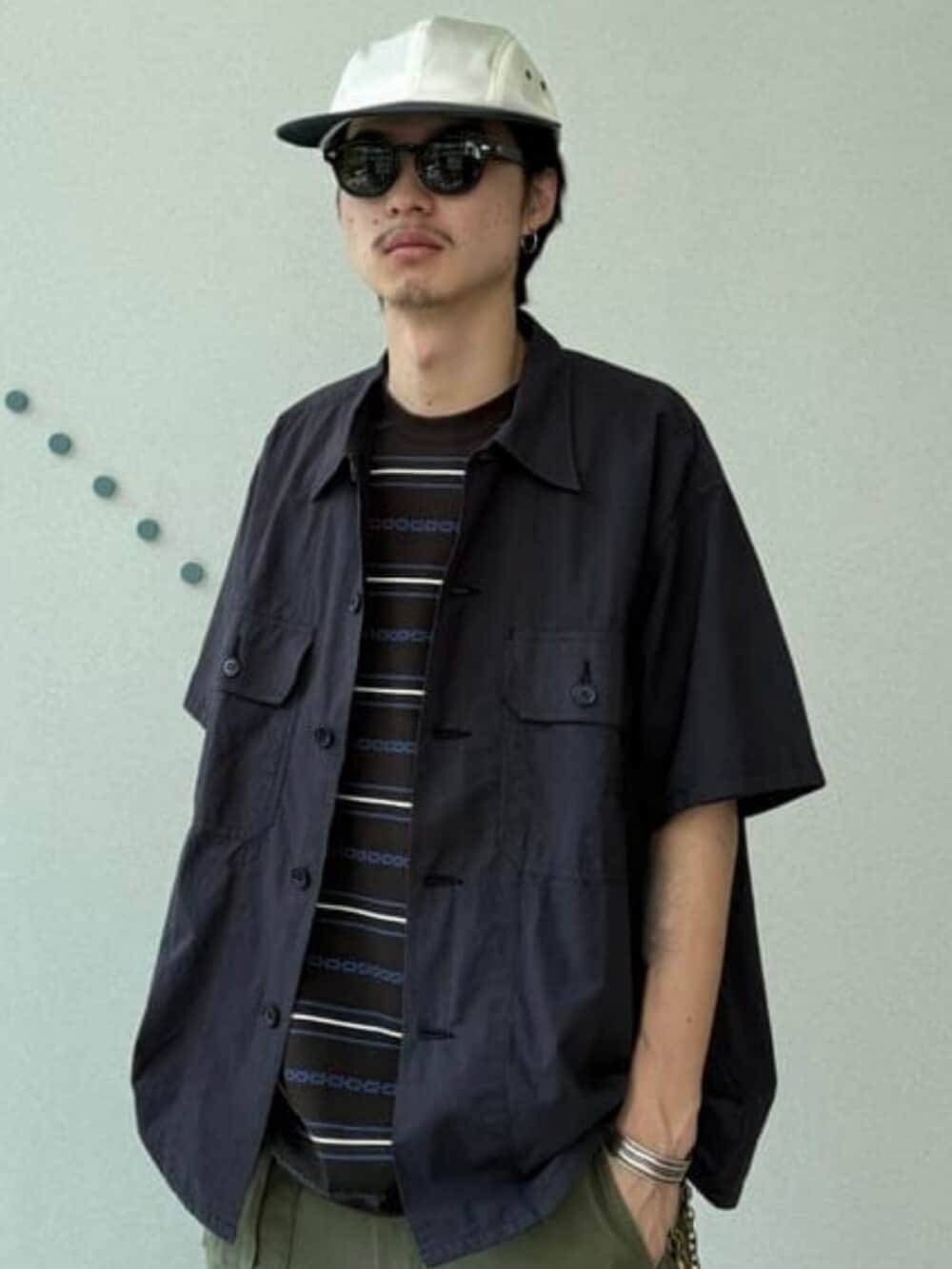 ブラウン系のTシャツ/カットソー、ブルー系のシャツ/ブラウス、ブラック系のスニーカーを着用したメンズの夏コーディネートの3枚目の写真