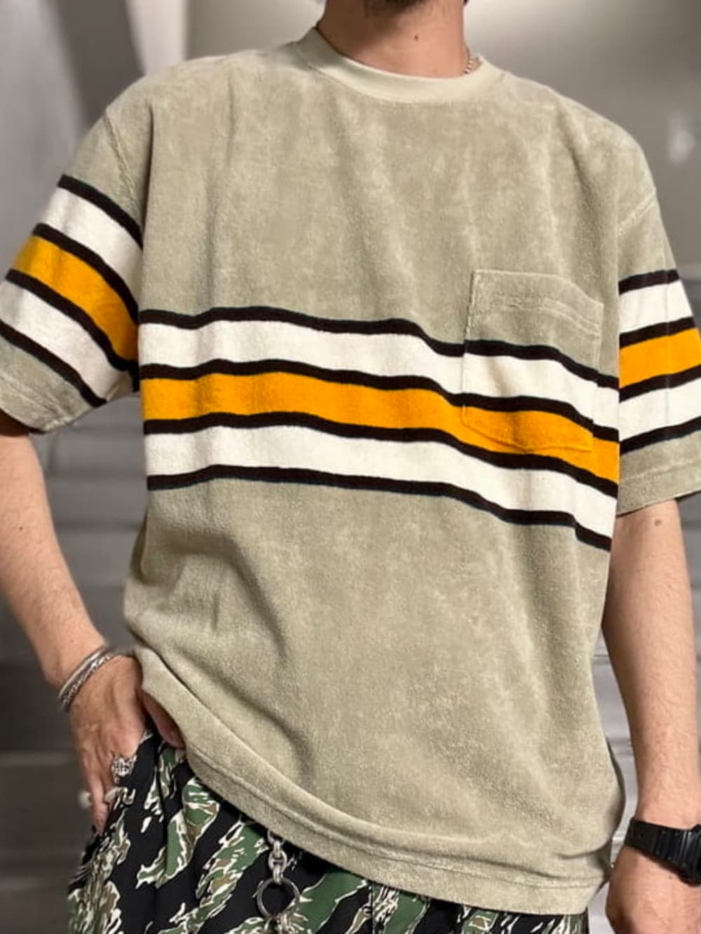 ブラウン系のトートバッグ、ベージュ系のTシャツ/カットソーを着用したメンズの夏コーディネートの3枚目の写真