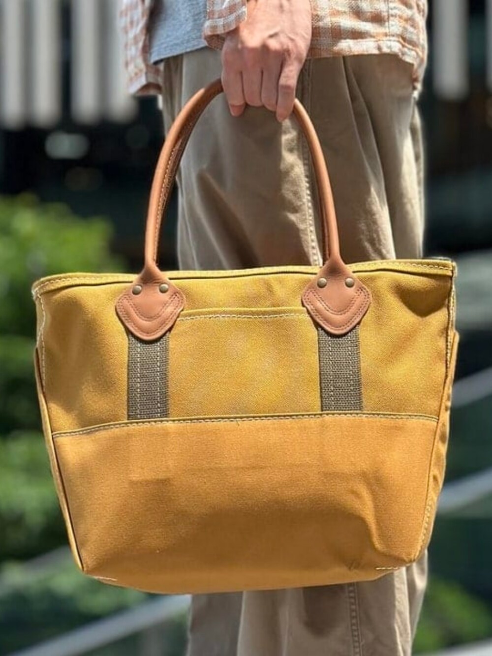 ブラウン系のトートバッグ、グレー系のTシャツ/カットソー、オレンジ系のシャツ/ブラウスを着用したメンズの夏コーディネートの5枚目の写真