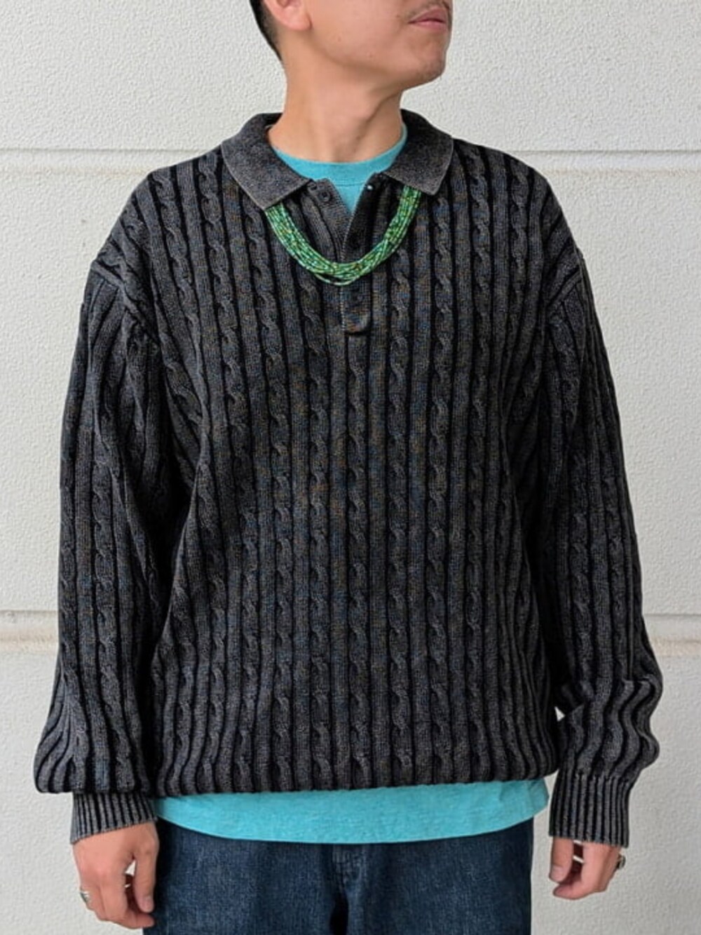 ブルー系のデニムパンツ、ブラック系のポロシャツ、グリーン系のTシャツ/カットソーを着用したメンズの秋コーディネートの2枚目の写真