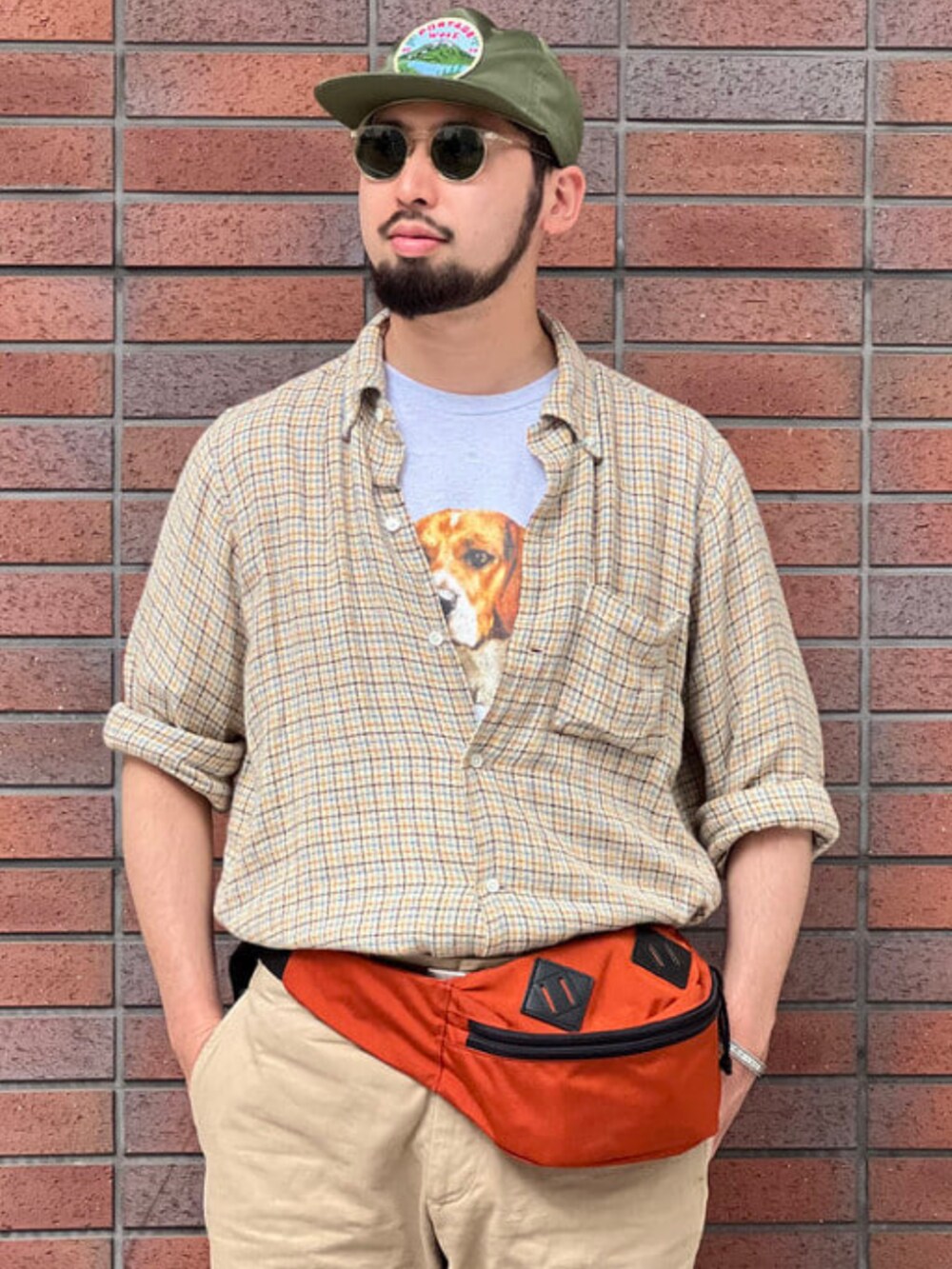 オレンジ系のボディバッグ/ウエストポーチ、ベージュ系のシャツ/ブラウス、グレー系のTシャツ/カットソーを着用したメンズの夏コーディネートの2枚目の写真