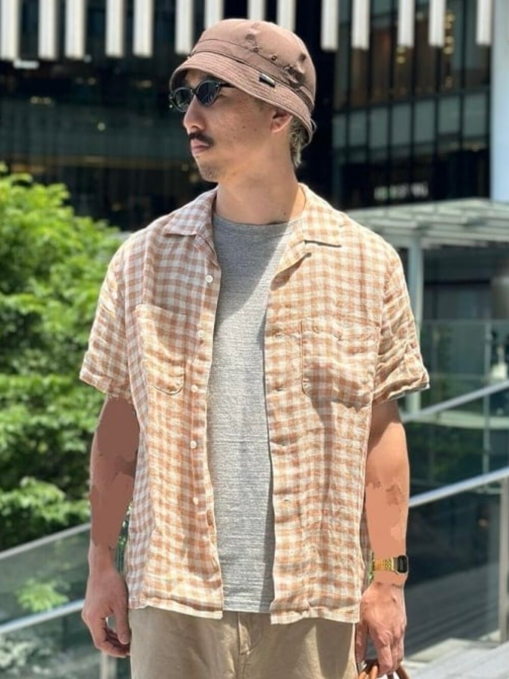 ブラウン系のトートバッグ、グレー系のTシャツ/カットソー、オレンジ系のシャツ/ブラウスを着用したメンズの夏コーディネートの3枚目の写真