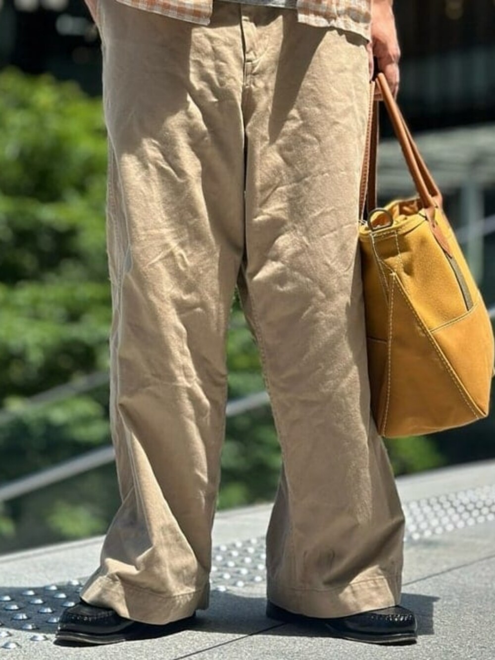 ブラウン系のトートバッグ、グレー系のTシャツ/カットソー、オレンジ系のシャツ/ブラウスを着用したメンズの夏コーディネートの4枚目の写真