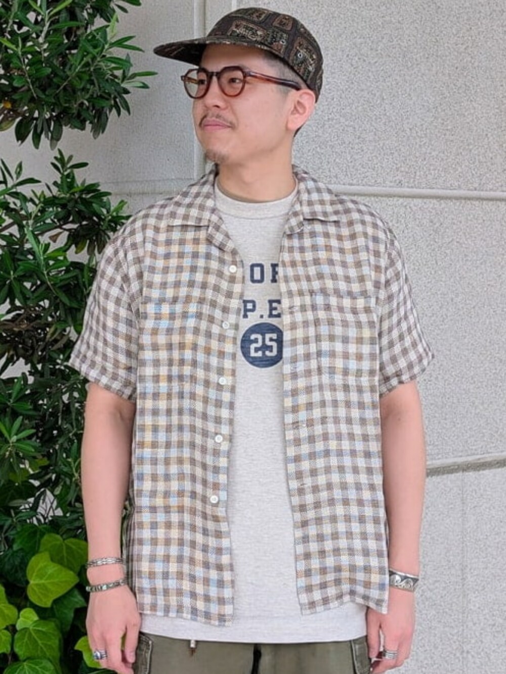 ブラウン系のシャツ/ブラウス、ホワイト系のTシャツ/カットソー、グリーン系のカーゴパンツを着用したメンズの夏コーディネートの3枚目の写真