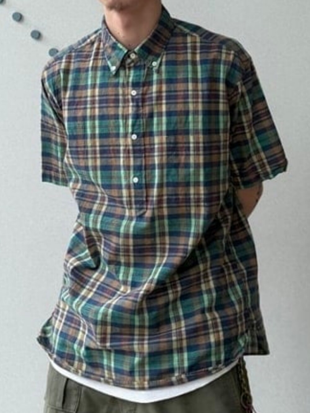 ブルー系のシャツ/ブラウス、ブラック系のスニーカー、レッド系のキャップを着用したメンズの夏コーディネートの2枚目の写真