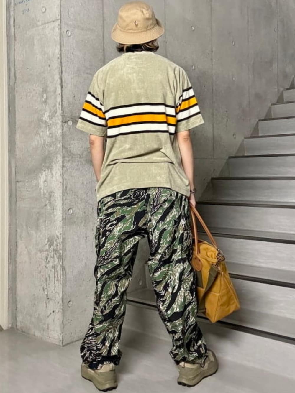 ブラウン系のトートバッグ、ベージュ系のTシャツ/カットソーを着用したメンズの夏コーディネートの2枚目の写真