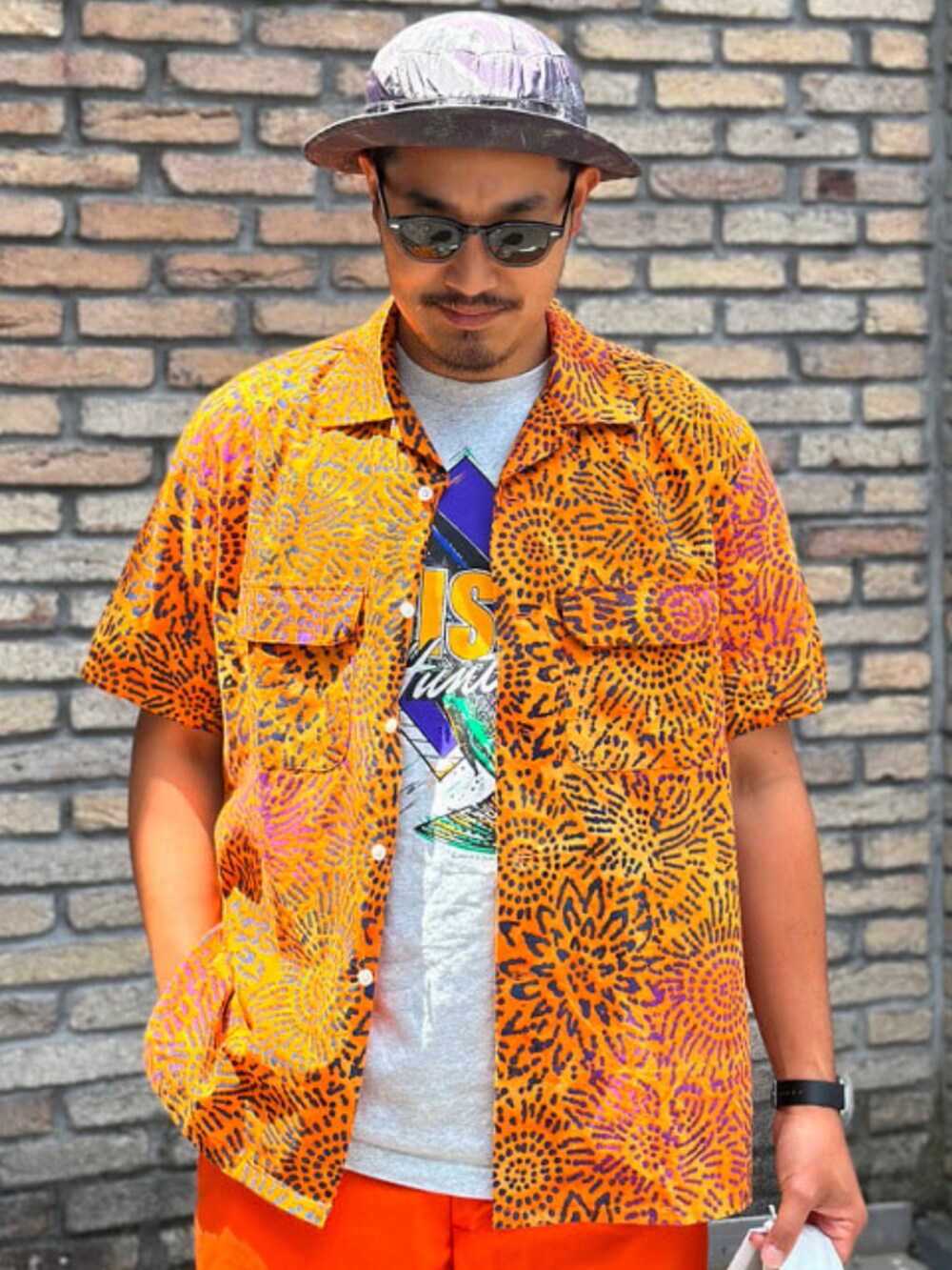 オレンジ系のその他パンツ、オレンジ系のシャツ/ブラウス、その他のハットを着用したメンズの夏コーディネートの2枚目の写真