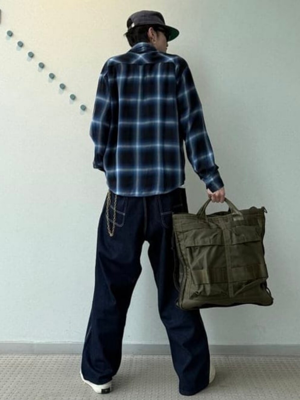 ブラック系のシャツ/ブラウス、グリーン系のトートバッグ、ブルー系のデニムパンツを着用したメンズの春コーディネートの2枚目の写真