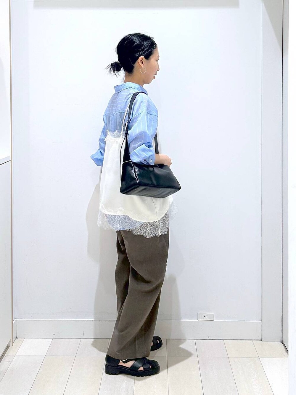 ブラウン系のその他パンツ、ブラック系のショルダーバッグ、ブルー系のシャツ/ブラウスを着用したレディースの春コーディネートの4枚目の写真