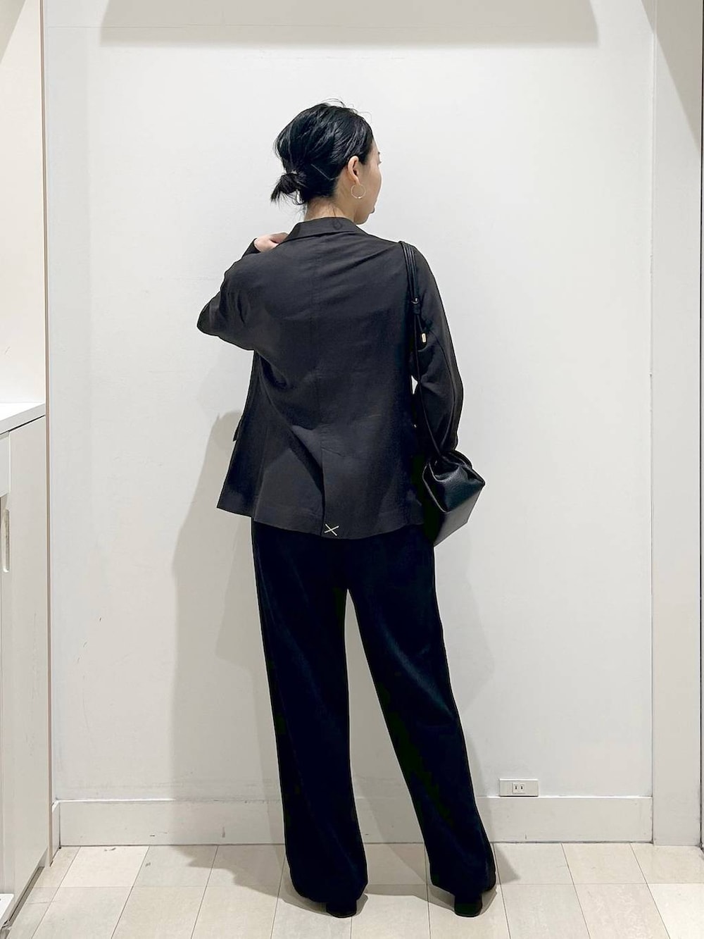 ブラック系のローファー、ブラック系のショルダーバッグ、ブラック系のテーラードジャケットを着用したレディースの春コーディネートの3枚目の写真