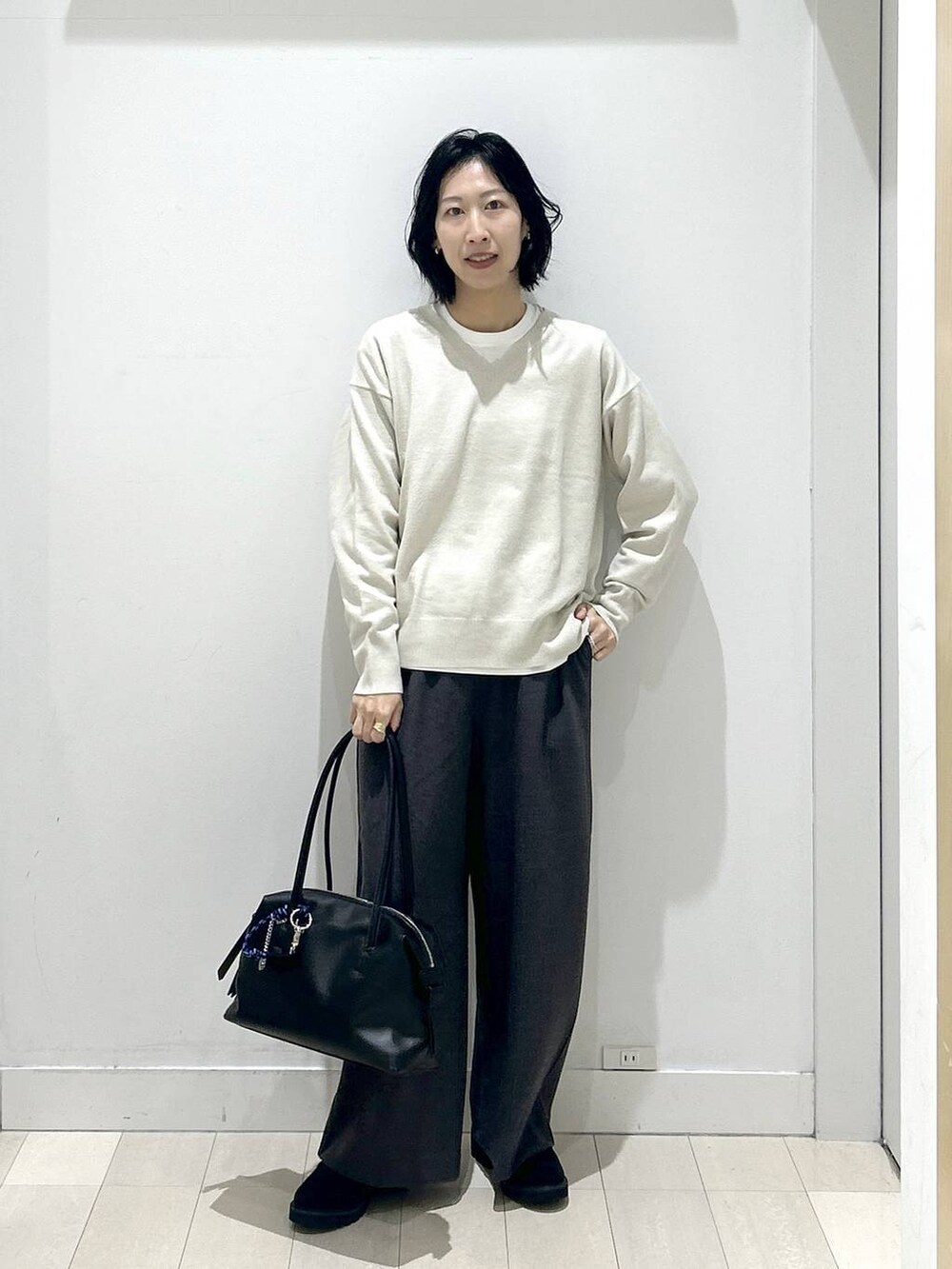 ブラック系のボストンバッグ、ブラック系のローファー、ホワイト系のTシャツ/カットソーを着用したレディースの秋コーディネートの5枚目の写真