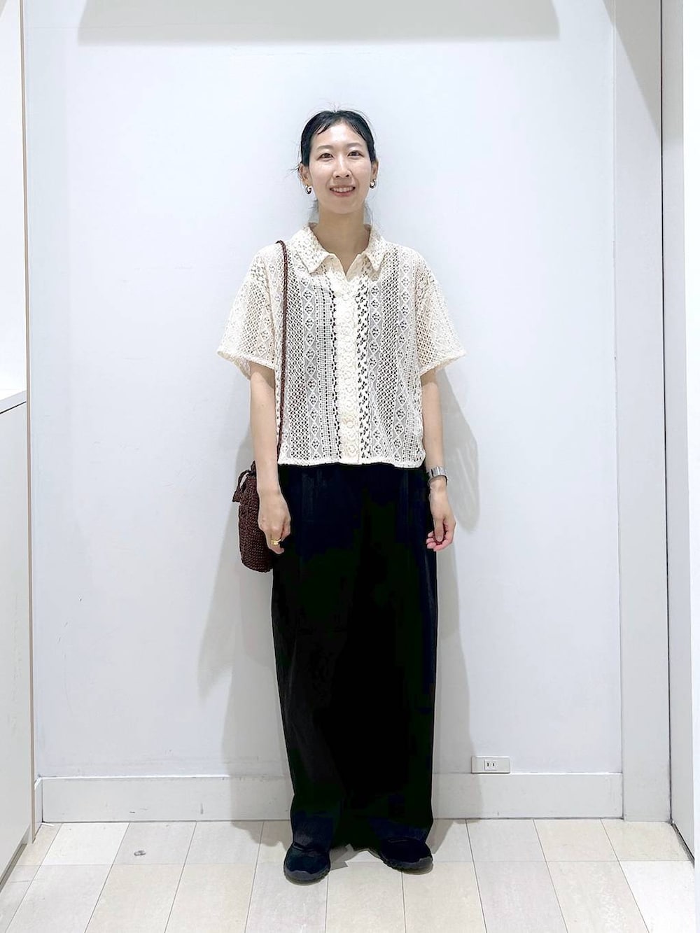 ブラック系のその他パンツ、ブラウン系のクラッチバッグ、ブラック系のスニーカーを着用したレディースの春コーディネートの5枚目の写真