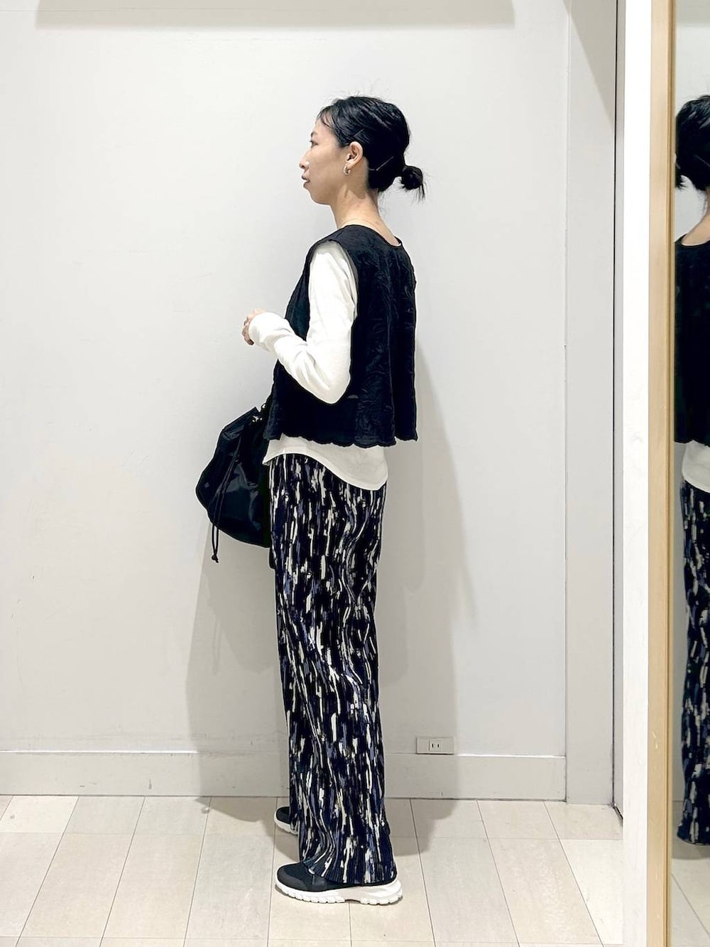 ブラック系のスニーカー、ブラック系のショルダーバッグ、ブルー系のその他パンツを着用したレディースの春コーディネートの2枚目の写真