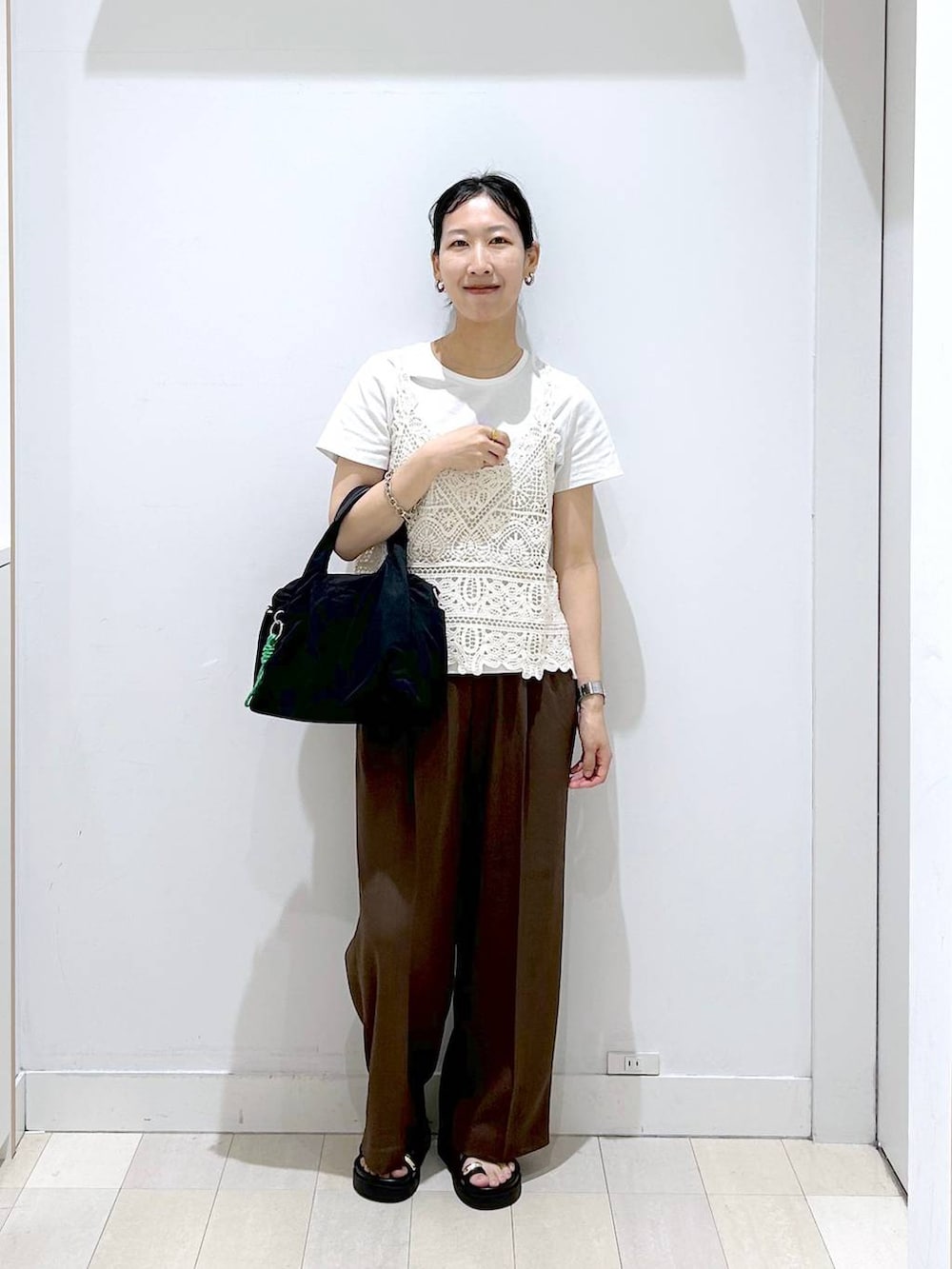ブラック系のトートバッグ、ブラウン系のその他パンツ、ホワイト系のTシャツ/カットソーを着用したレディースの夏コーディネートの5枚目の写真