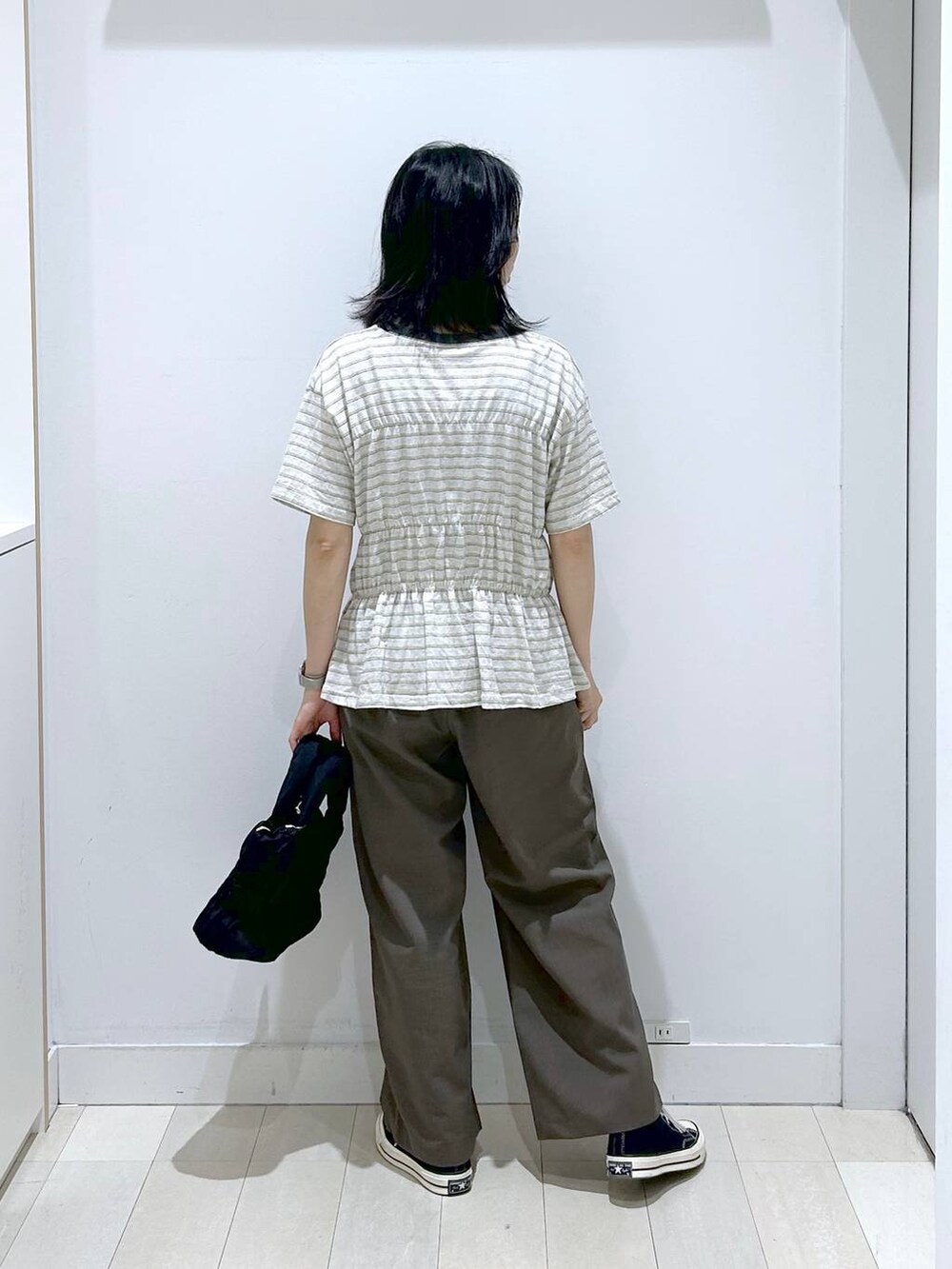 ブラック系のトートバッグ、ブラウン系のその他パンツ、ホワイト系のTシャツ/カットソーを着用したレディースの夏コーディネートの3枚目の写真