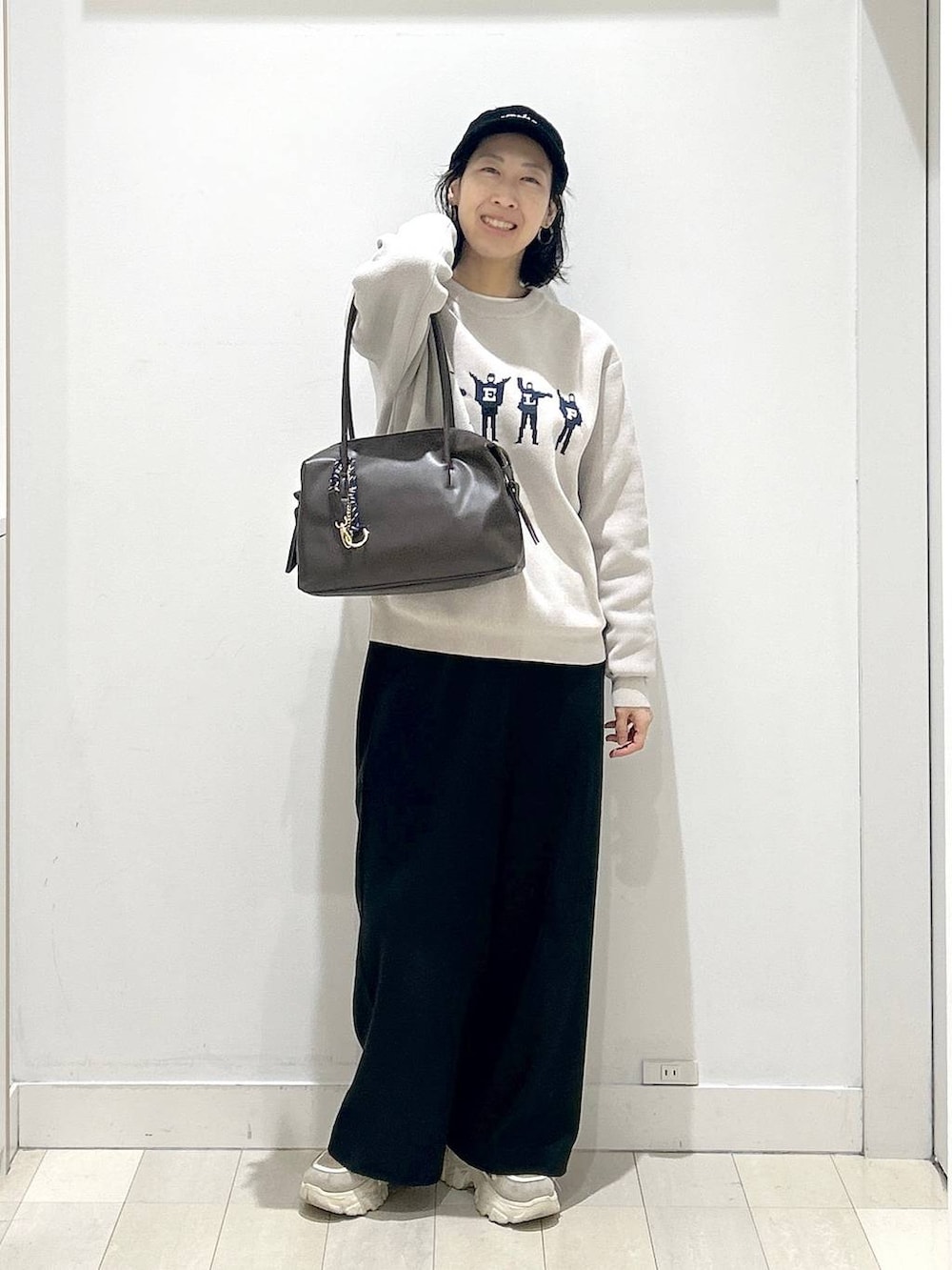 ブラウン系のボストンバッグ、ブラック系のその他パンツ、ベージュ系のTシャツ/カットソーを着用したレディースの冬コーディネートの5枚目の写真