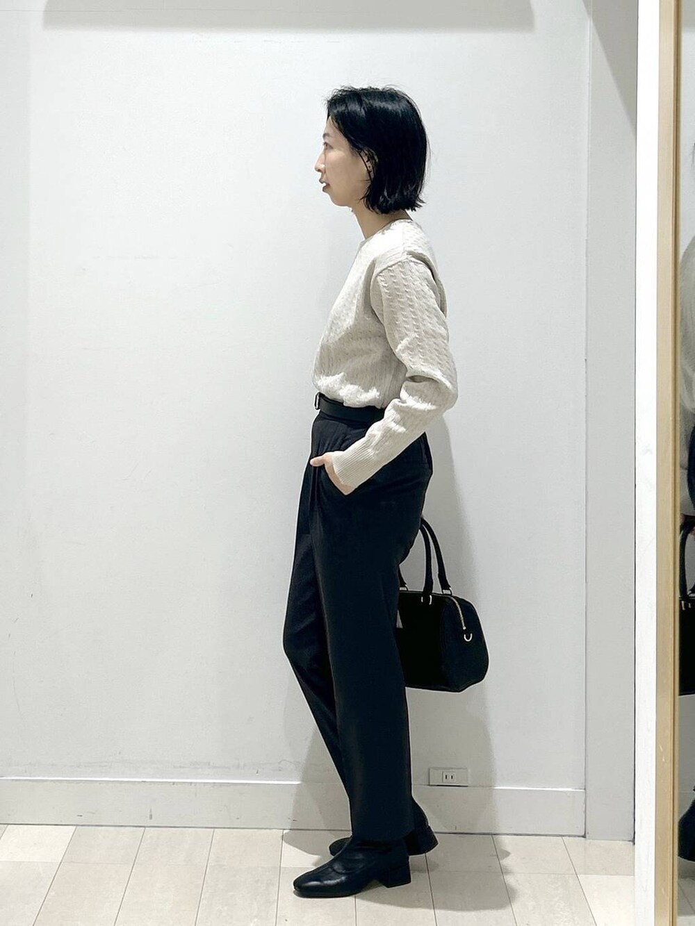 グレー系のその他パンツ、ブラック系のボストンバッグ、ブラック系のブーツを着用したレディースの冬コーディネートの4枚目の写真