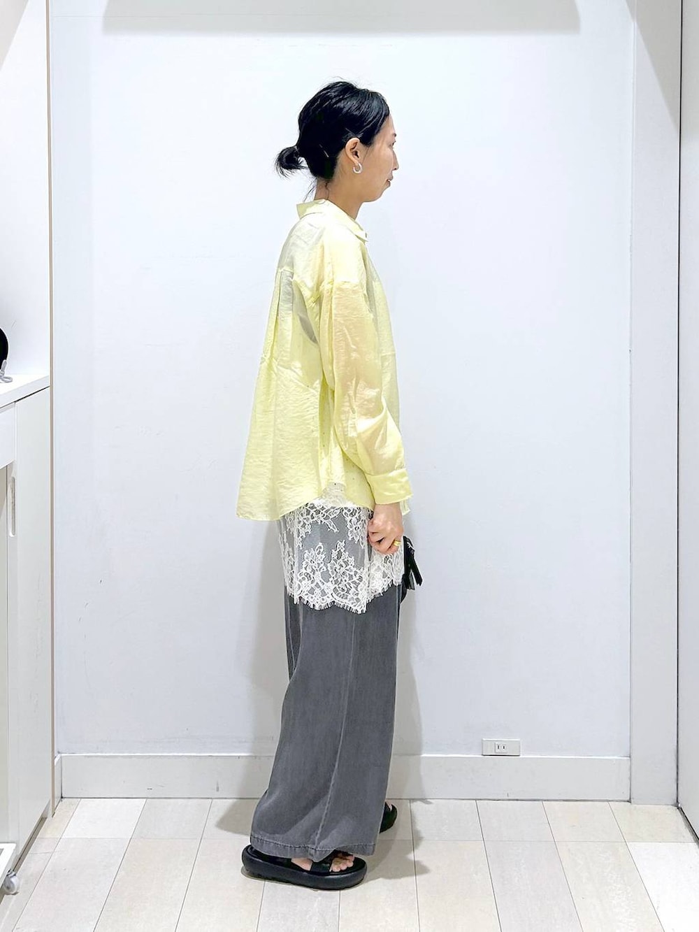 イエロー系のシャツ/ブラウス、ホワイト系のキャミソール、ブラック系のデニムパンツを着用したレディースの春コーディネートの4枚目の写真