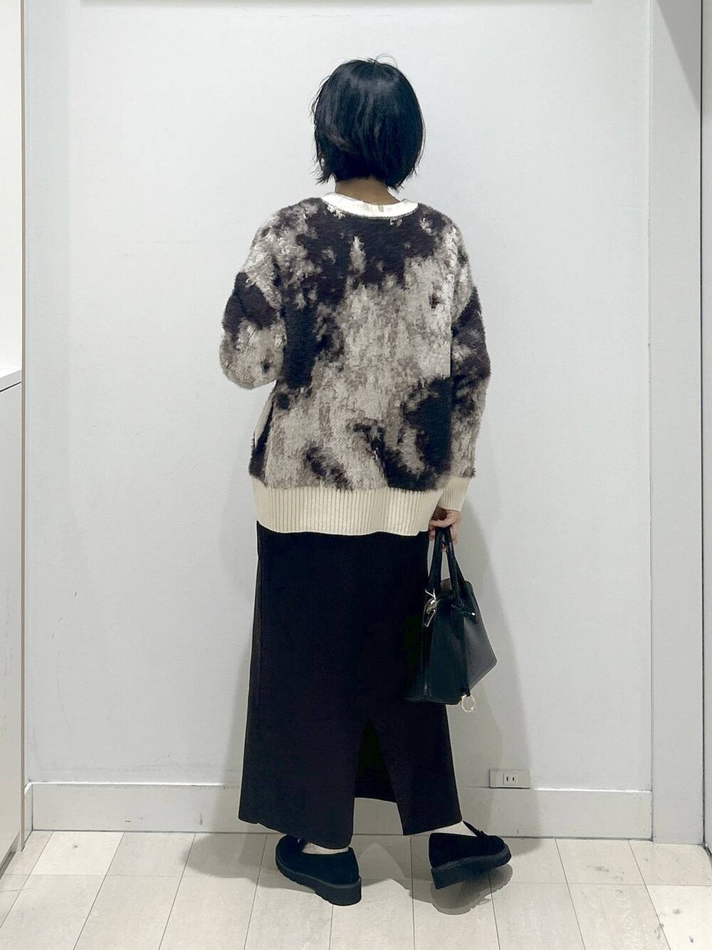 ブラック系のショルダーバッグ、ブラック系のローファー、ホワイト系のTシャツ/カットソーを着用したレディースの秋コーディネートの3枚目の写真