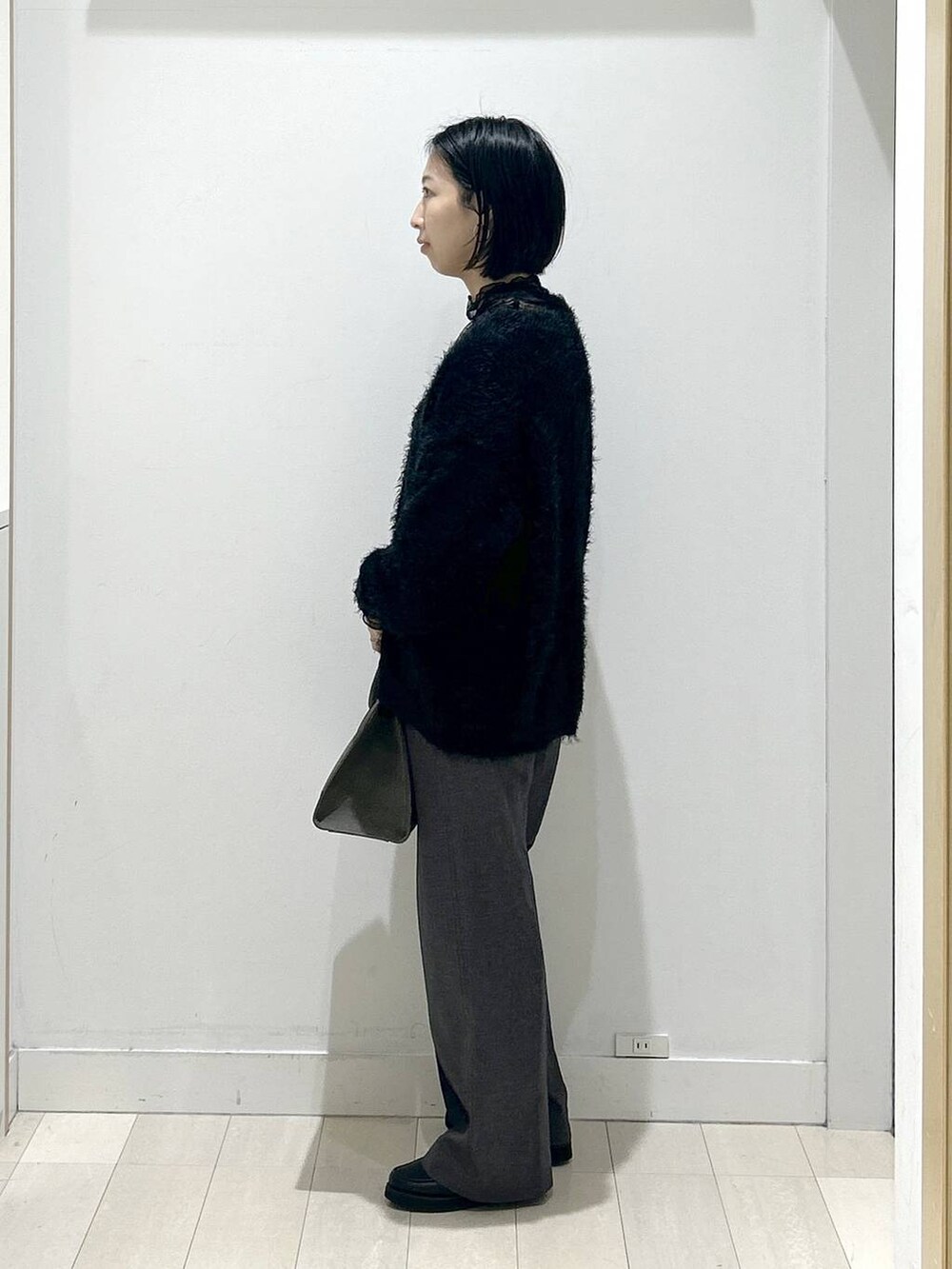 ブラック系のローファー、グレー系のその他パンツ、グリーン系のショルダーバッグを着用したレディースの秋コーディネートの4枚目の写真