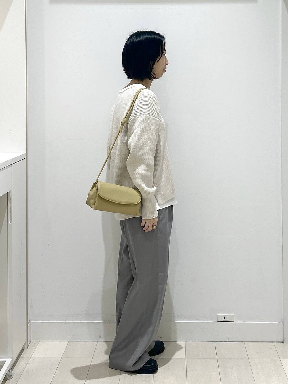 ブラック系のローファー、イエロー系のショルダーバッグ、ホワイト系のTシャツ/カットソーを着用したレディースの秋コーディネートの2枚目の写真