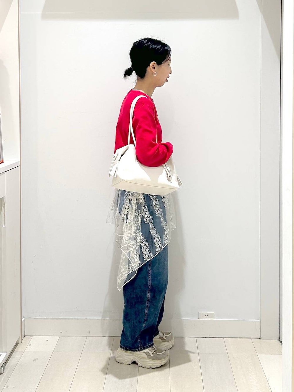 ホワイト系のボストンバッグ、ブルー系のデニムパンツ、ホワイト系のその他トップスを着用したレディースの春コーディネートの4枚目の写真