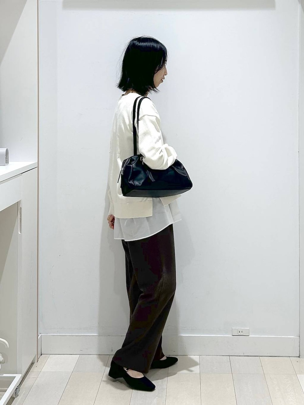 ベージュ系のニット/セーター、ブラウン系のその他パンツ、ホワイト系のタンクトップを着用したレディースの春コーディネートの4枚目の写真