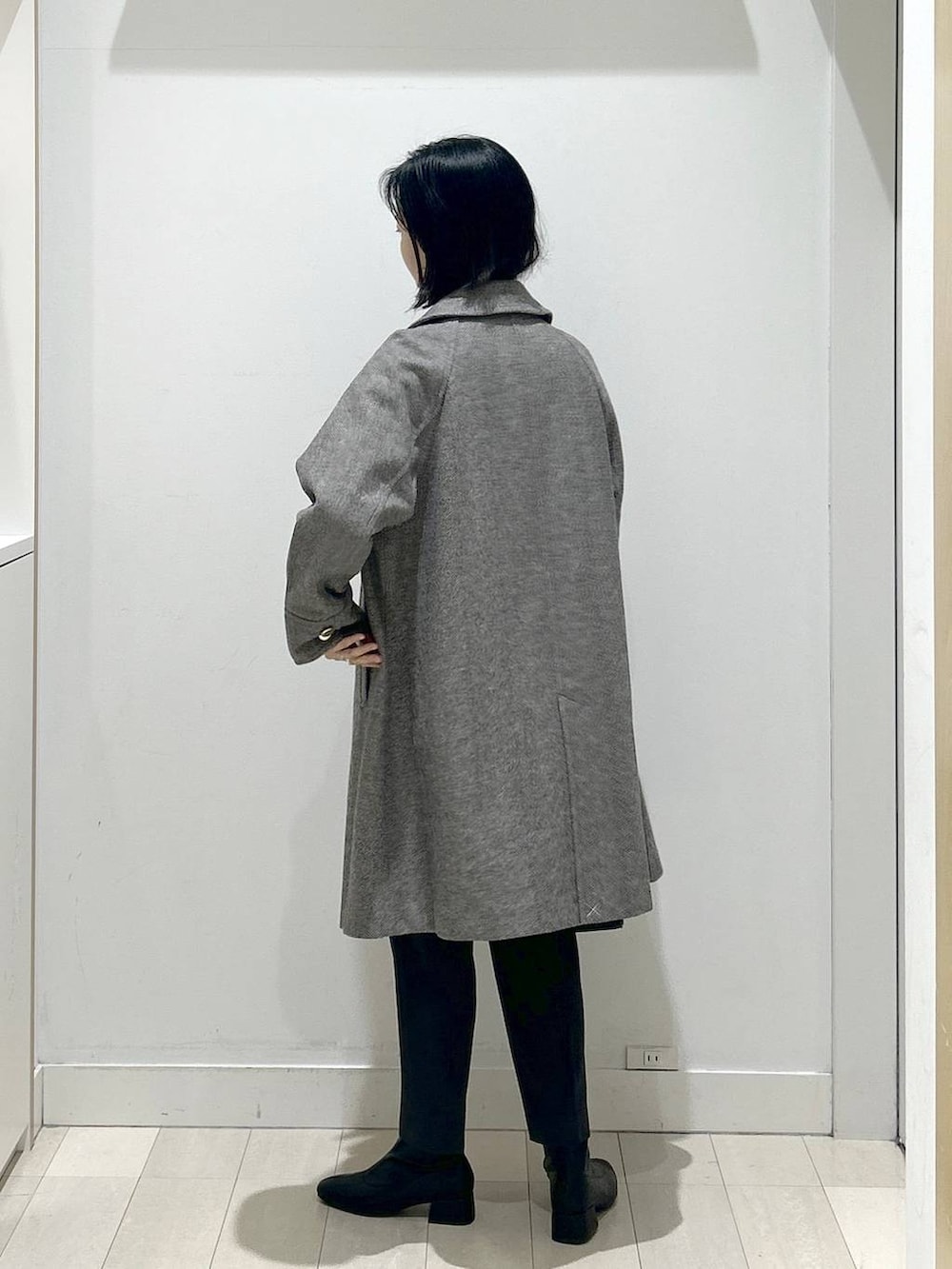 ブラウン系のチェスターコート、グレー系のその他パンツ、グレー系のニット/セーターを着用したレディースの冬コーディネートの3枚目の写真