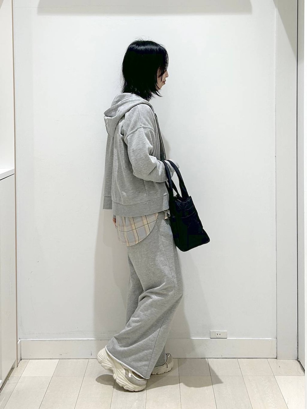 ブラック系のトートバッグ、ブルー系のシャツ/ブラウス、グレー系のパーカーを着用したレディースの春コーディネートの4枚目の写真