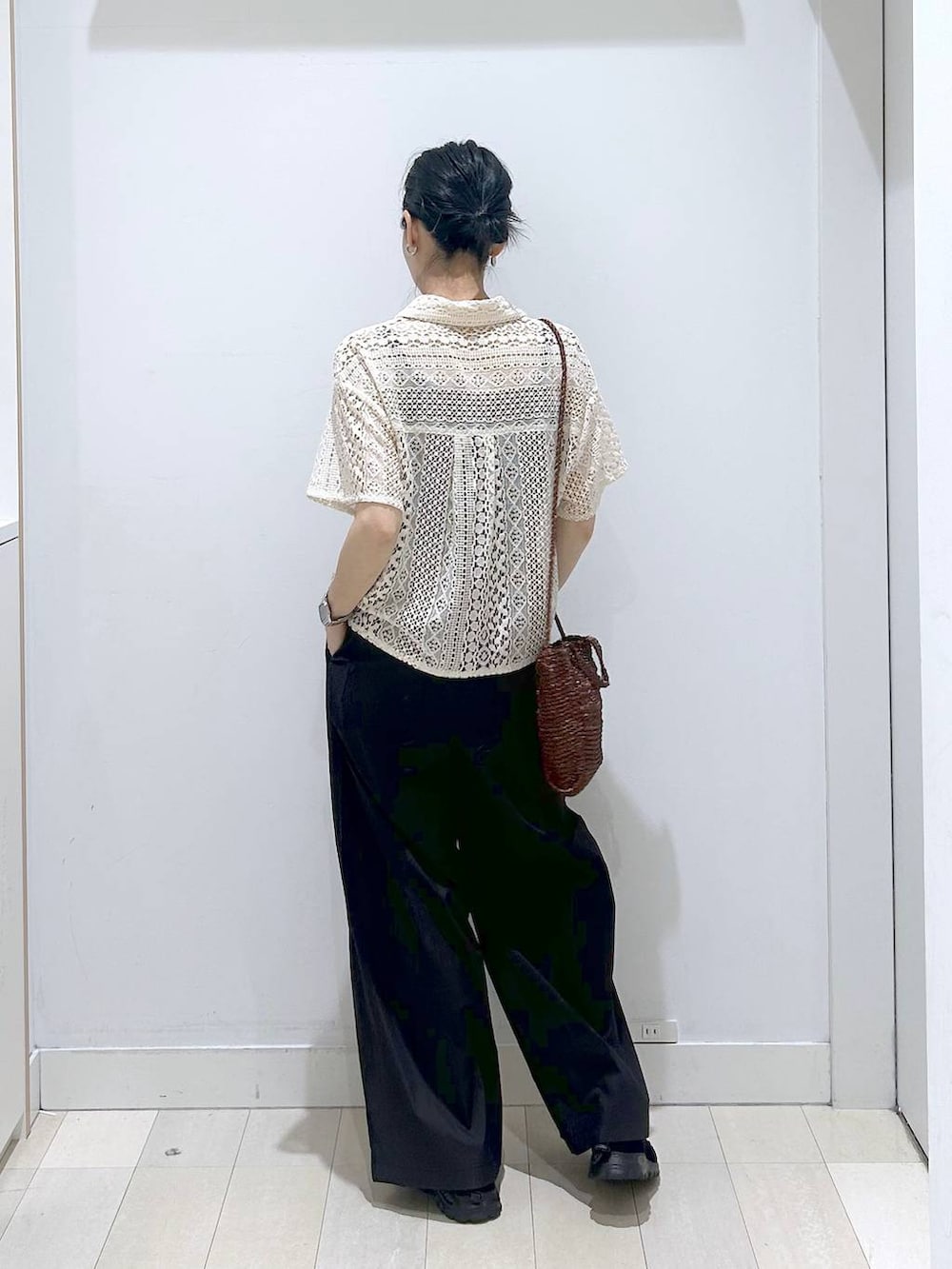 ブラック系のその他パンツ、ブラウン系のクラッチバッグ、ブラック系のスニーカーを着用したレディースの春コーディネートの3枚目の写真