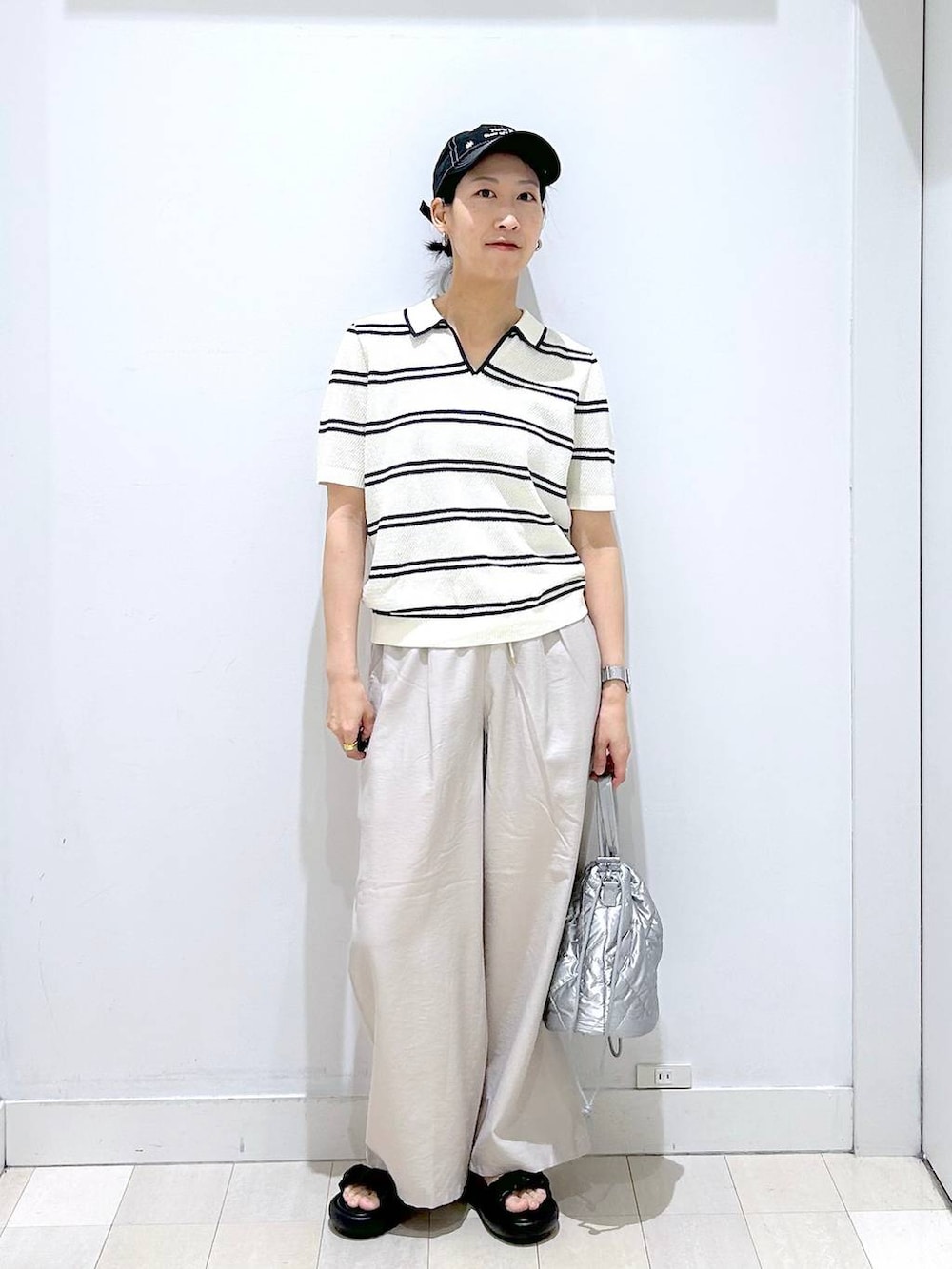 シルバー系のハンドバッグ、ベージュ系のその他パンツ、ホワイト系のニット/セーターを着用したレディースの春コーディネートの5枚目の写真