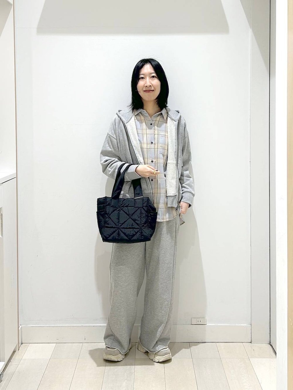 ブラック系のトートバッグ、ブルー系のシャツ/ブラウス、グレー系のパーカーを着用したレディースの春コーディネートの5枚目の写真