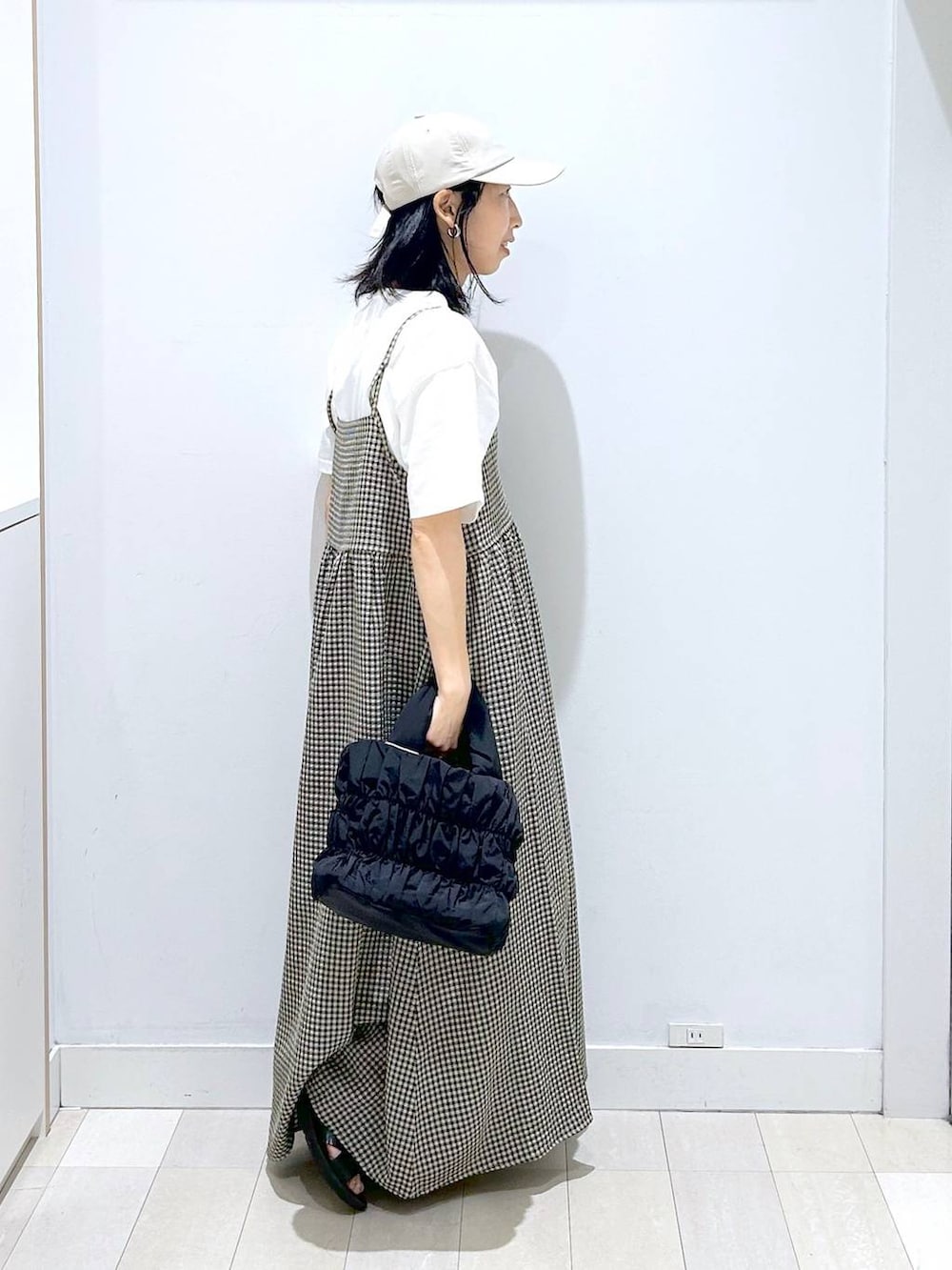 ブルー系のデニムパンツ、ブラック系のトートバッグ、ホワイト系のTシャツ/カットソーを着用したレディースの夏コーディネートの4枚目の写真