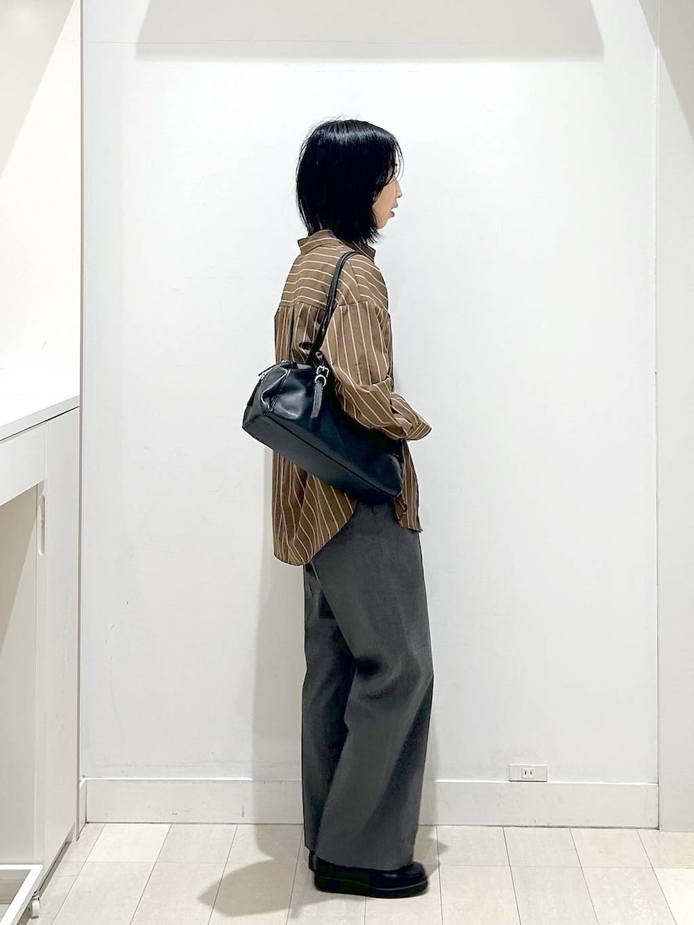 ブラック系のローファー、ブラウン系のシャツ/ブラウス、グレー系のスラックスを着用したレディースの春コーディネートの4枚目の写真