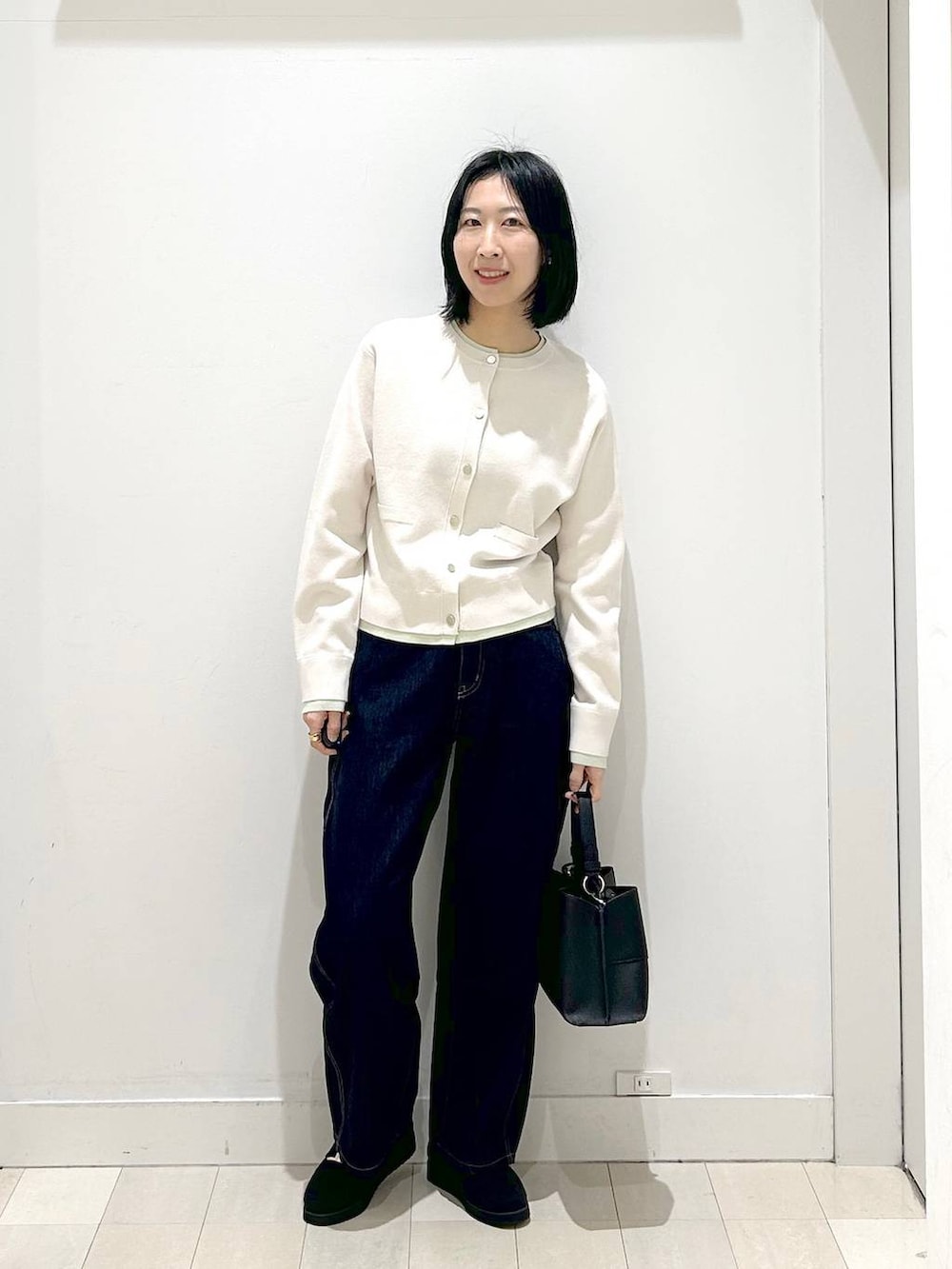 ブラック系のローファー、ブラック系のショルダーバッグ、ブルー系のデニムパンツを着用したレディースの冬コーディネートの5枚目の写真