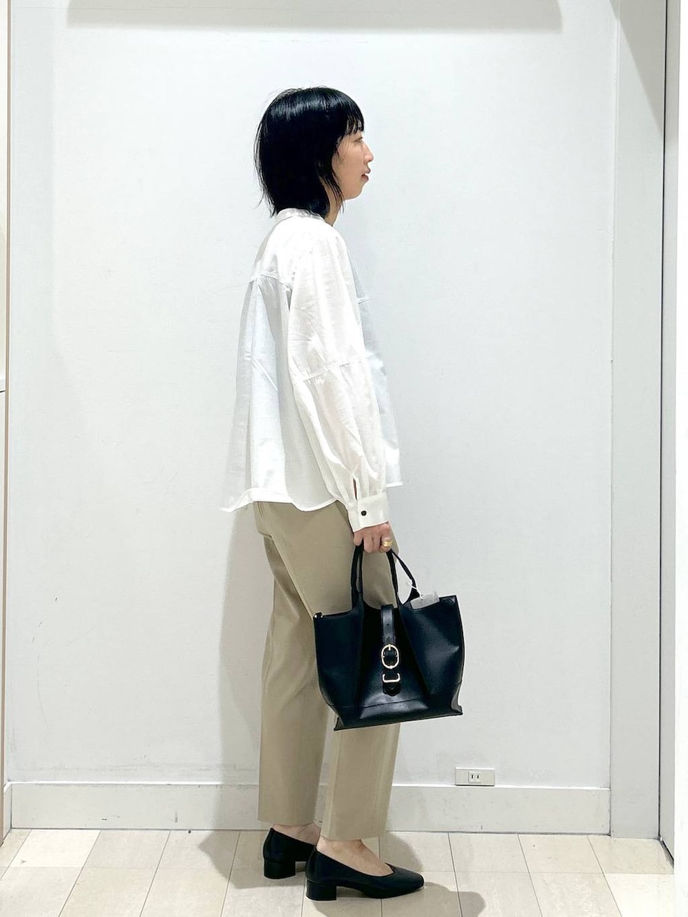 ベージュ系のその他パンツ、ブラック系のショルダーバッグ、ブラック系のパンプスを着用したレディースの春コーディネートの2枚目の写真