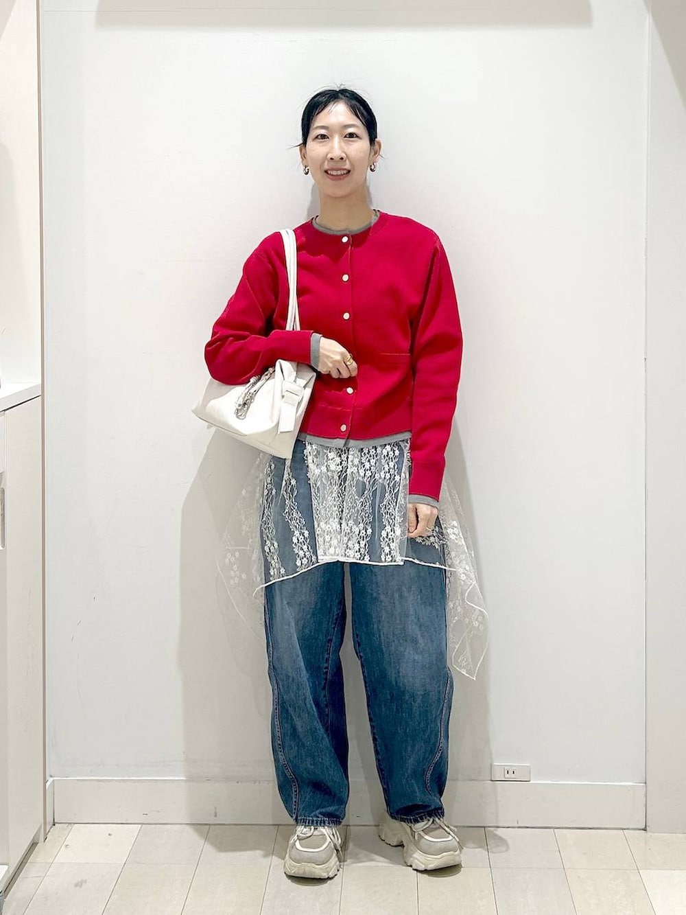 ホワイト系のボストンバッグ、ブルー系のデニムパンツ、ホワイト系のその他トップスを着用したレディースの春コーディネートの5枚目の写真