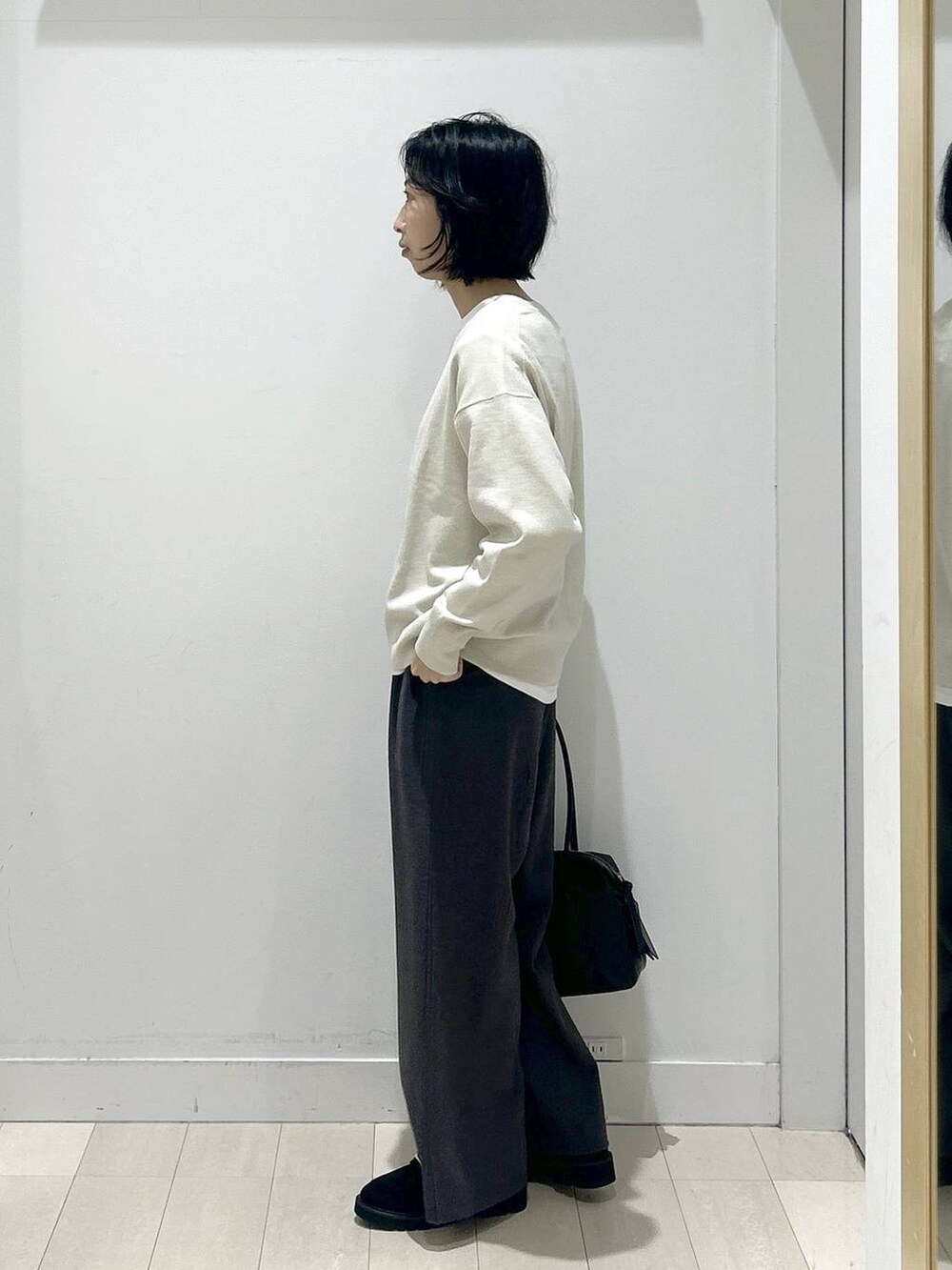 ブラック系のボストンバッグ、ブラック系のローファー、ホワイト系のTシャツ/カットソーを着用したレディースの秋コーディネートの4枚目の写真