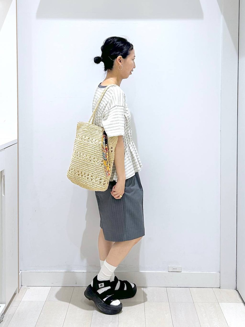 ベージュ系のトートバッグ、グレー系のその他パンツ、ホワイト系のTシャツ/カットソーを着用したレディースの夏コーディネートの4枚目の写真