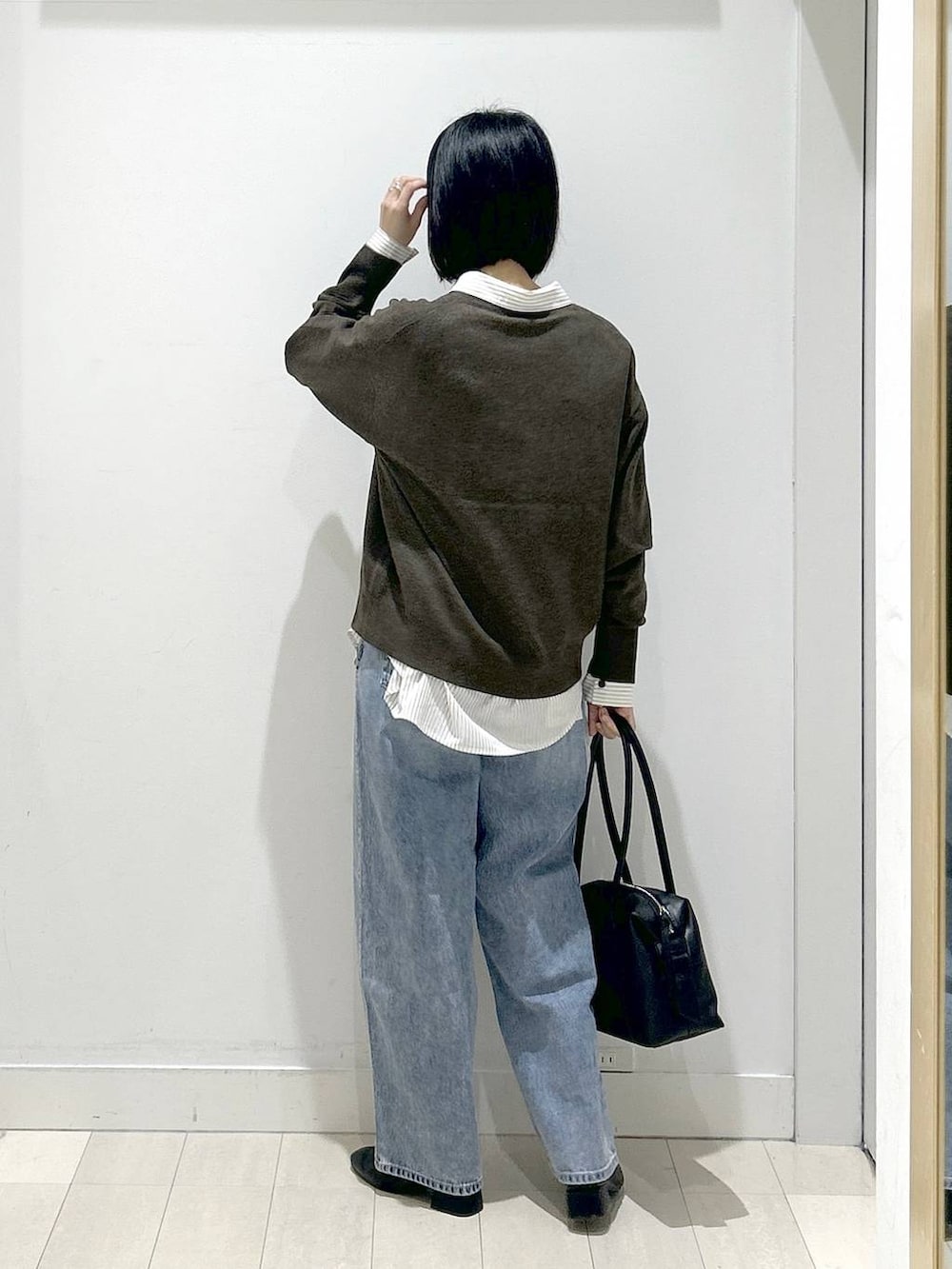 ブラック系のボストンバッグ、ブルー系のデニムパンツ、その他のシャツ/ブラウスを着用したレディースの冬コーディネートの3枚目の写真