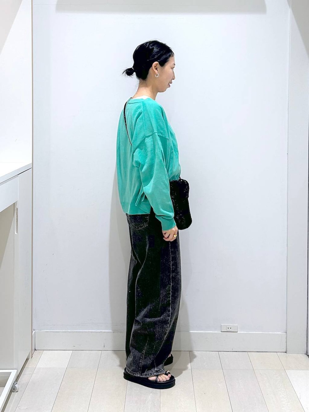 ブラック系のデニムパンツ、ホワイト系のTシャツ/カットソー、グリーン系のカーディガン/ボレロを着用したレディースの春コーディネートの4枚目の写真