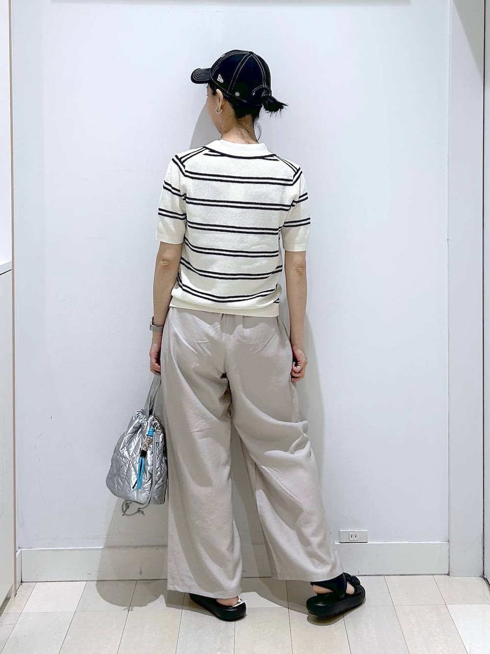 シルバー系のハンドバッグ、ベージュ系のその他パンツ、ホワイト系のニット/セーターを着用したレディースの春コーディネートの3枚目の写真