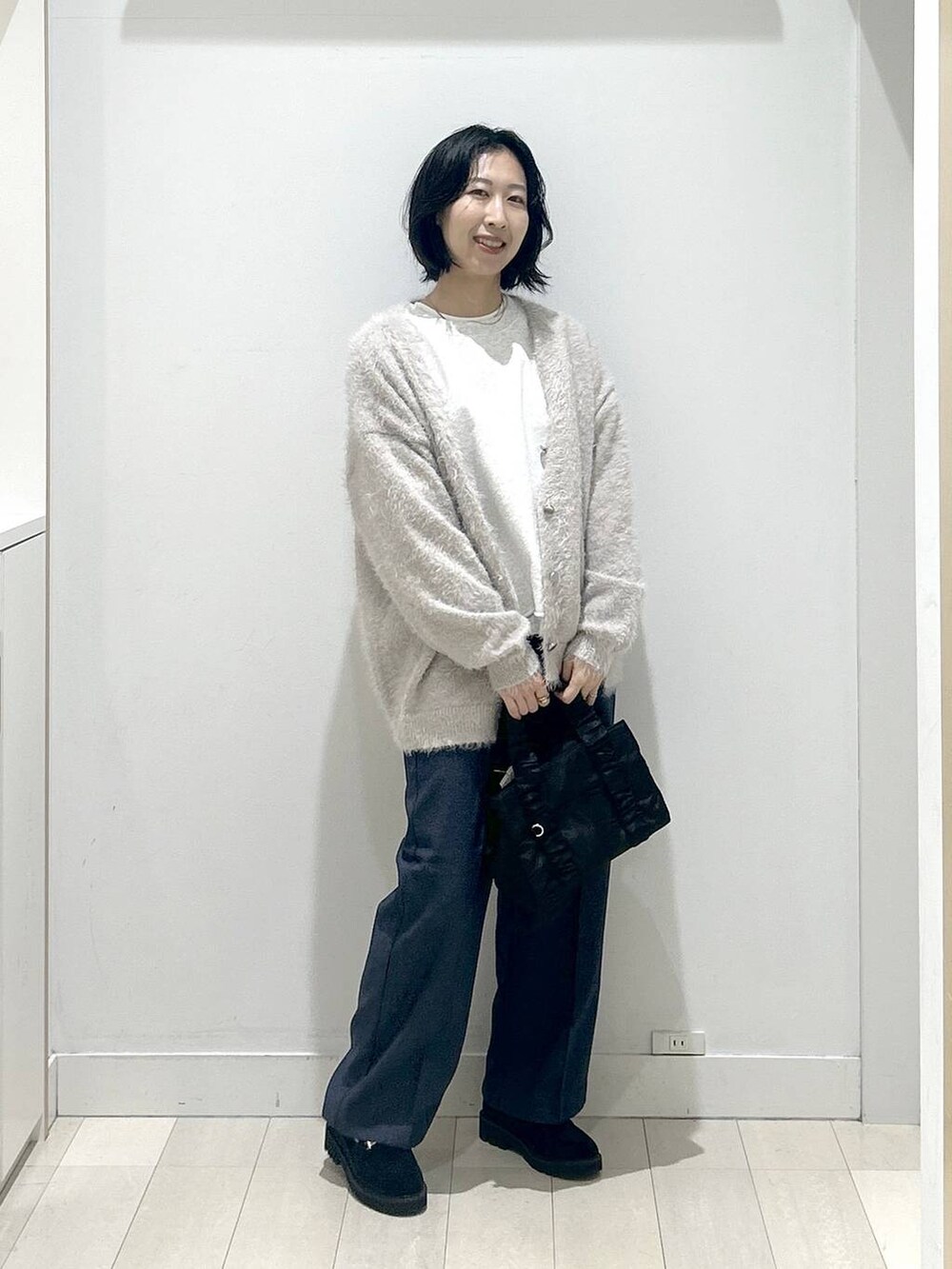 ブラック系のボストンバッグ、ブラック系のローファー、ブルー系のその他パンツを着用したレディースの秋コーディネートの5枚目の写真