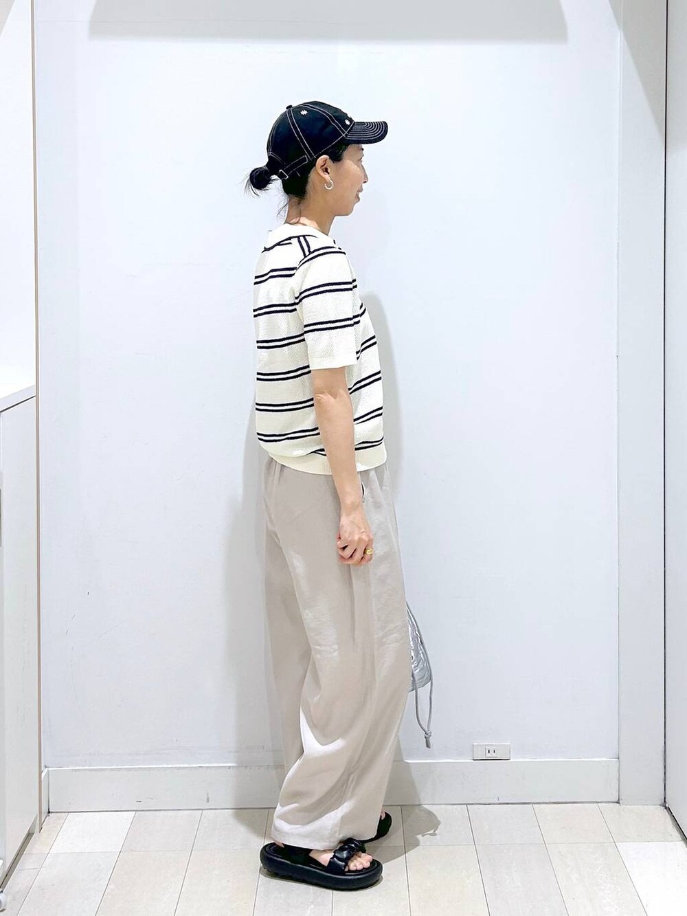 シルバー系のハンドバッグ、ベージュ系のその他パンツ、ホワイト系のニット/セーターを着用したレディースの春コーディネートの4枚目の写真